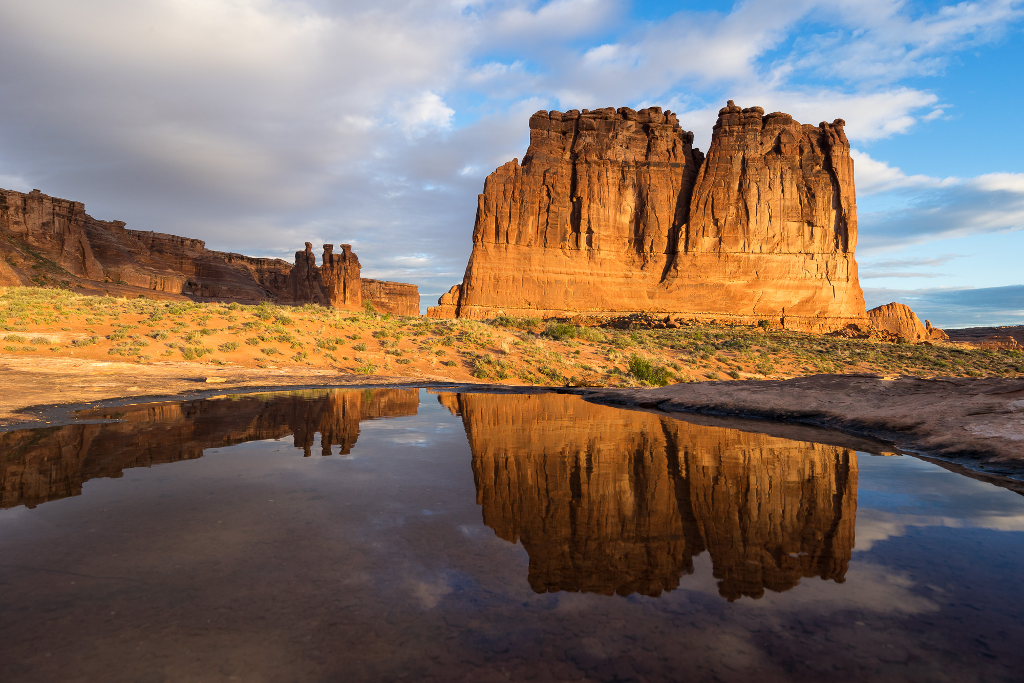 Courthouse Towers Reflecting in Pothole Below Clearing Storm, Arches National Park, Utah