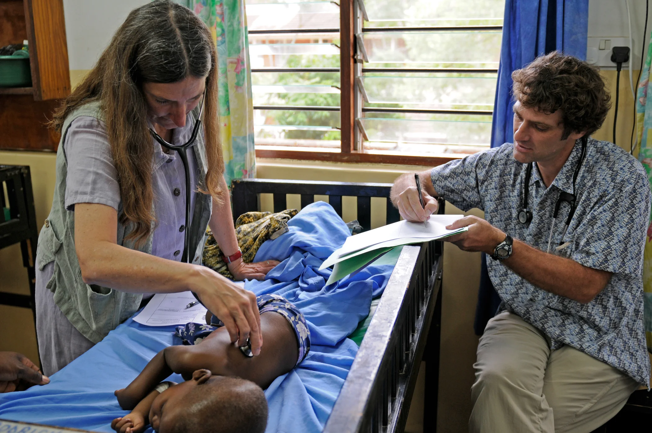 Karl Seydel and colleague Terrie Taylor with a patient in Malawi, where MSU has been helping people with malaria for 25 years. Photo by Jim Peck.