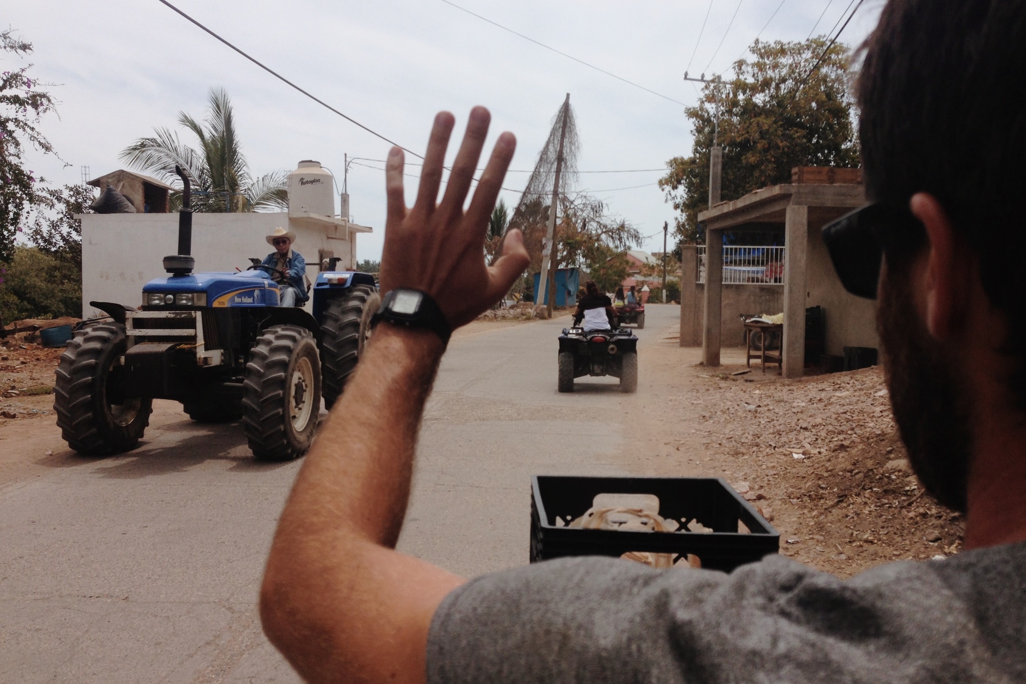 Waving while riding the quad through town