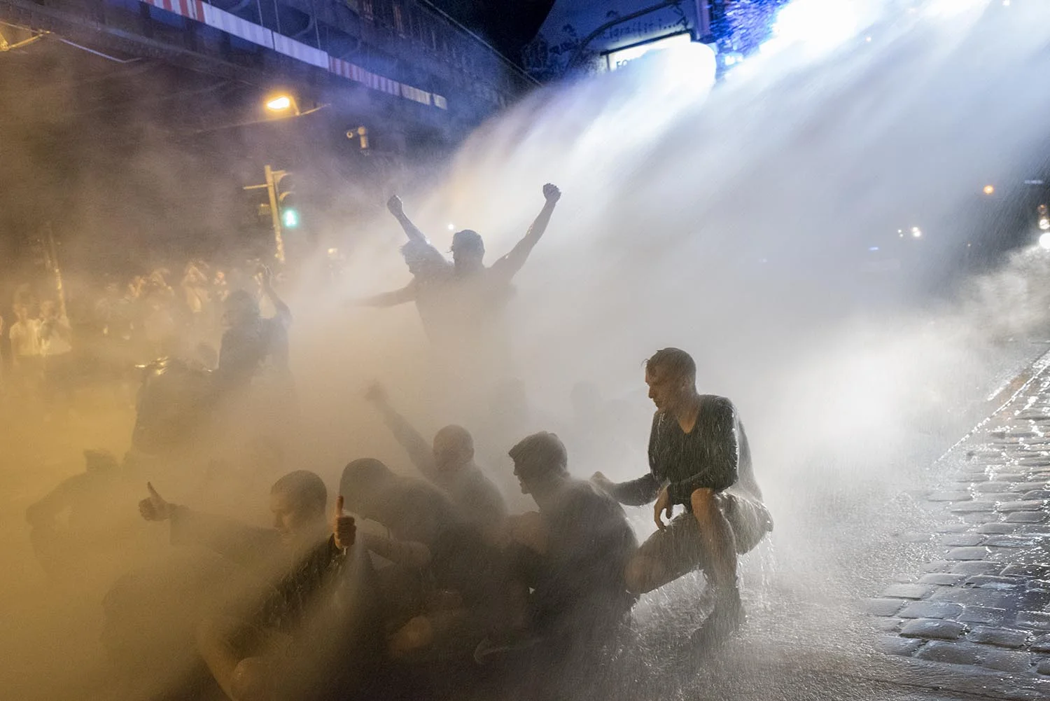 Demonstrators are sitting peaceful on the road in St. Pauli and the police does’nt know how to stop the road block. Modern watercannons always helps.