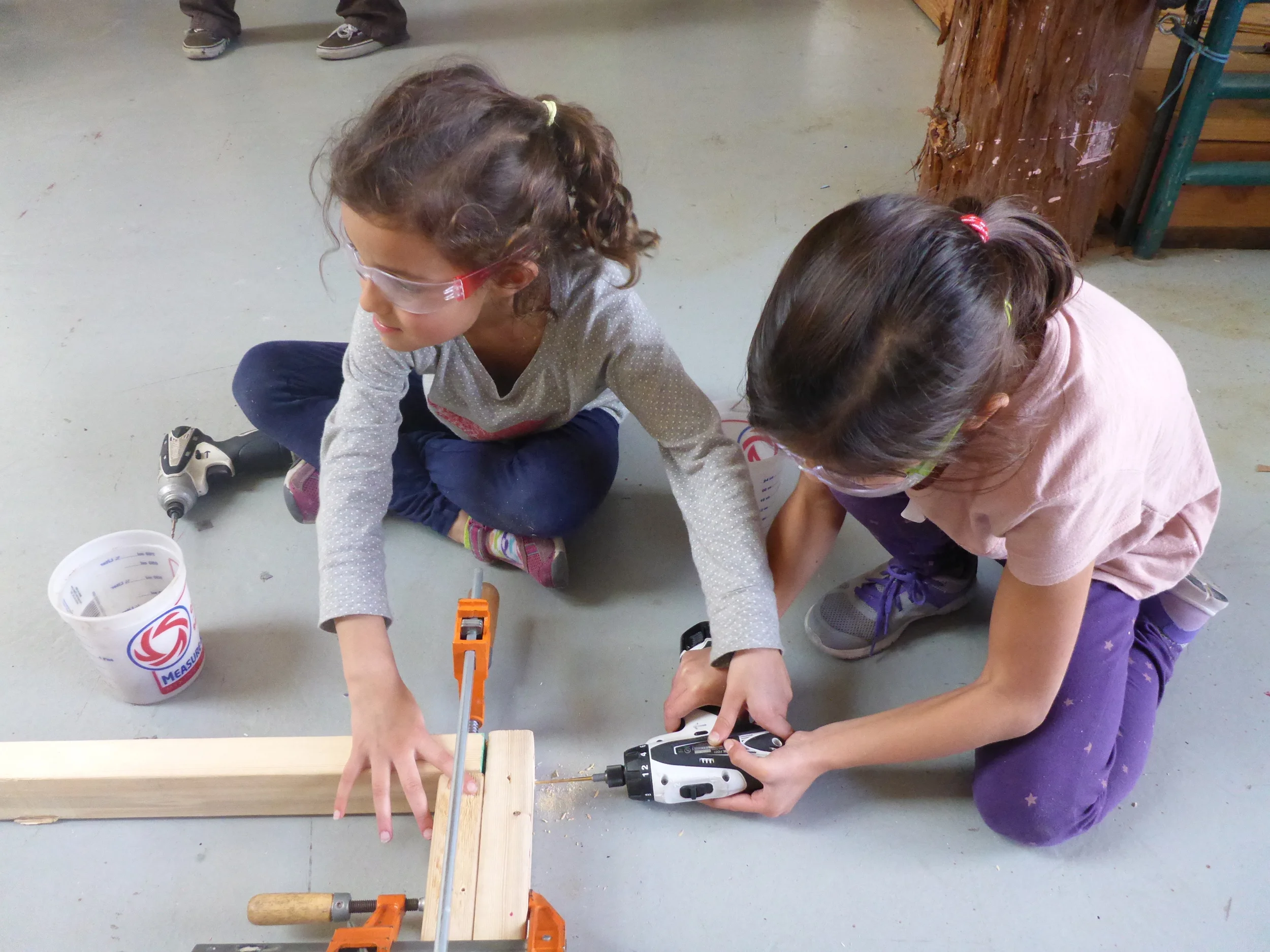 Sabi helps Aasha get some body weight behind the drill.