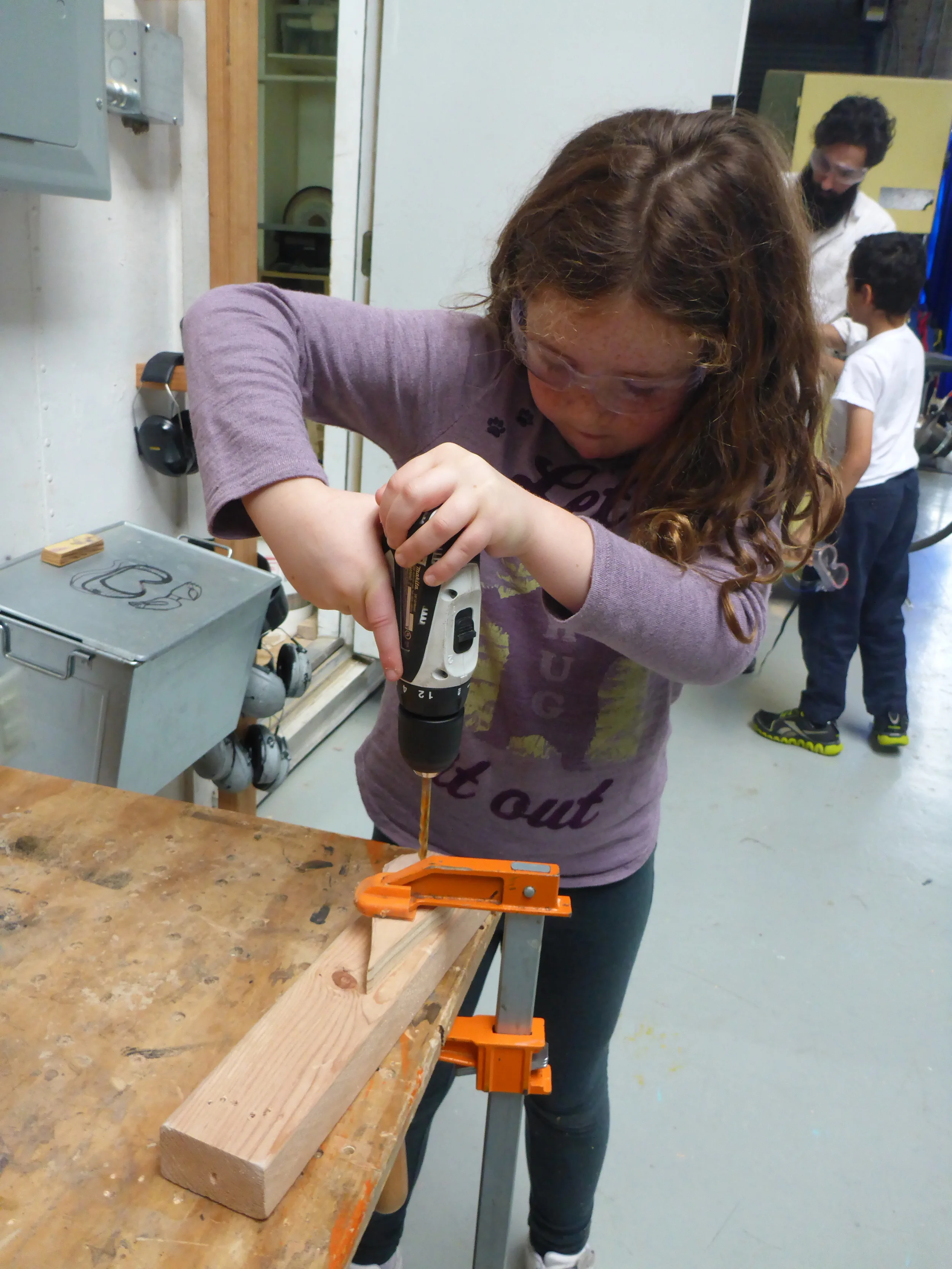 Maddie drills a hole to bolt down the flipper