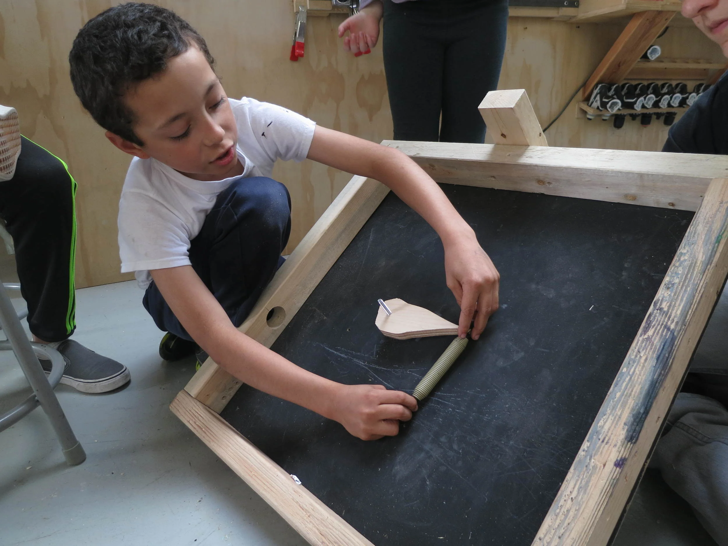Lucas shares with the rest of the group the placement and way to attach a tension styled spring to the flipper