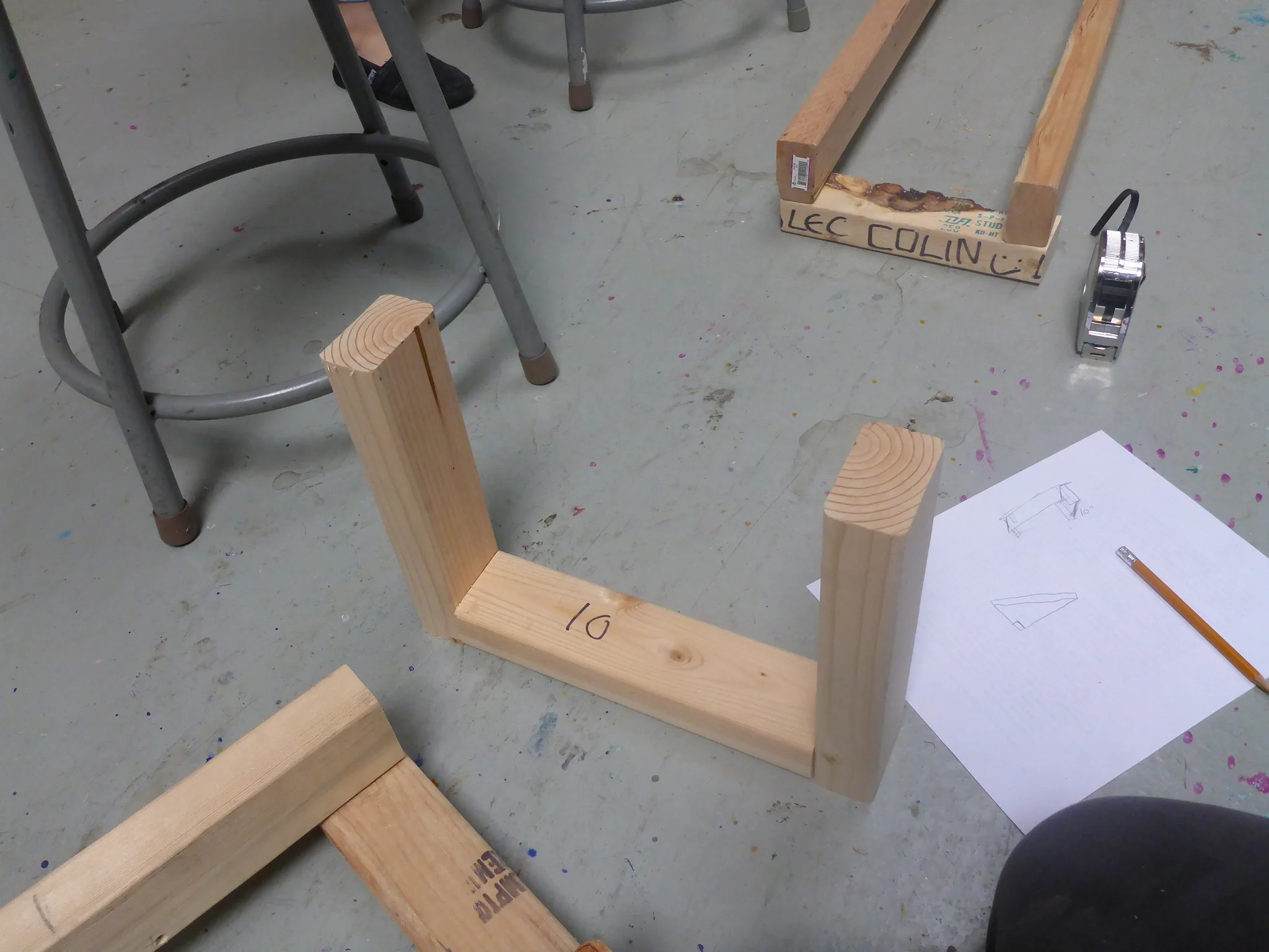 The team determines standard dimensions for a brace designed to hold suspended track in place. 