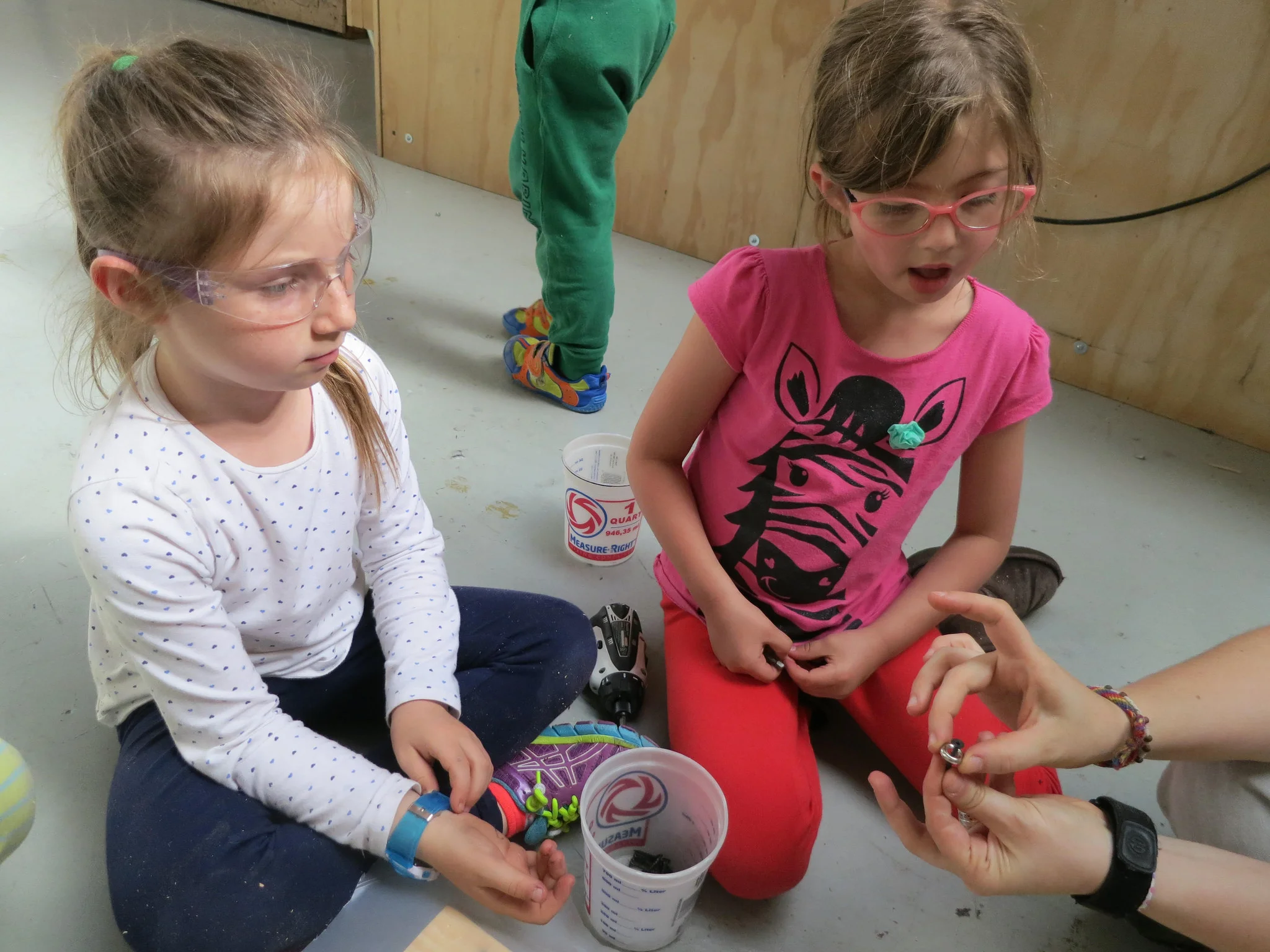 Miel and Kyra learn how a finishing washer added to a screw will help attach the new coating to the slide without tearing through the plastic. 