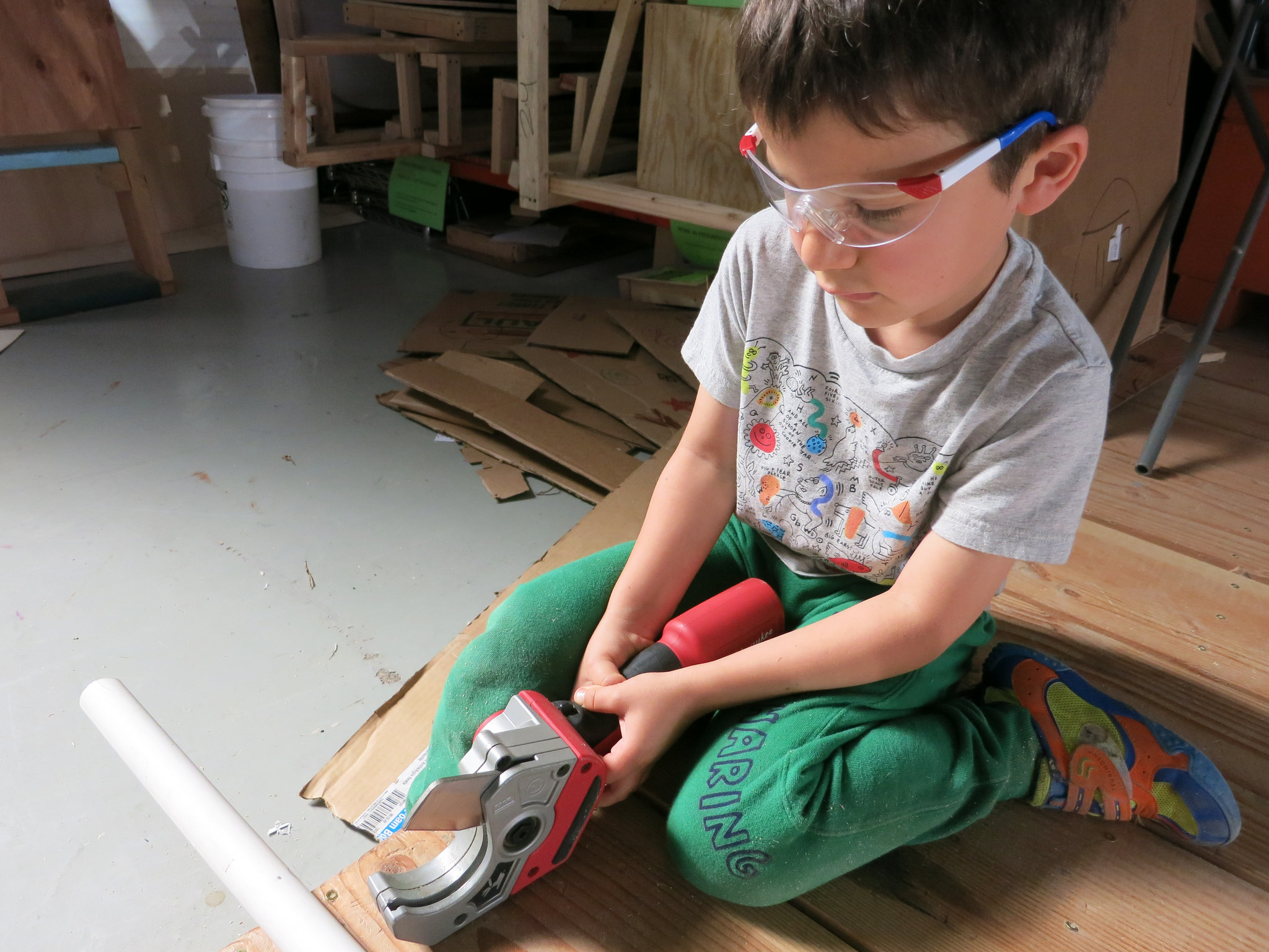 Max manages the electric PVC cutter to size the pipe so it can be secured into place between the platforms' "fences".