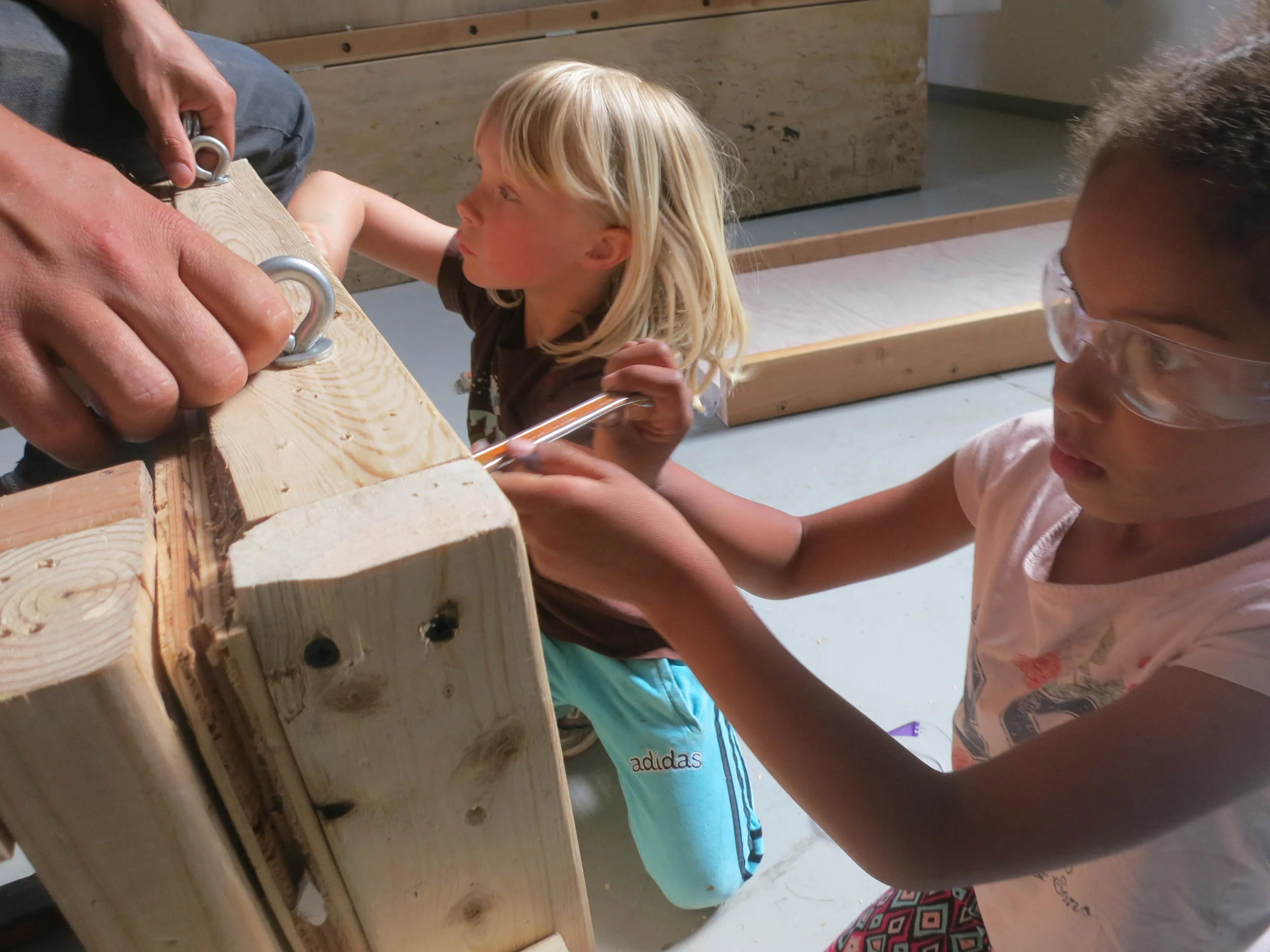 Attaching the eyebolts to the bottom of the platform -- they will later help us attach the slide to the platform. 