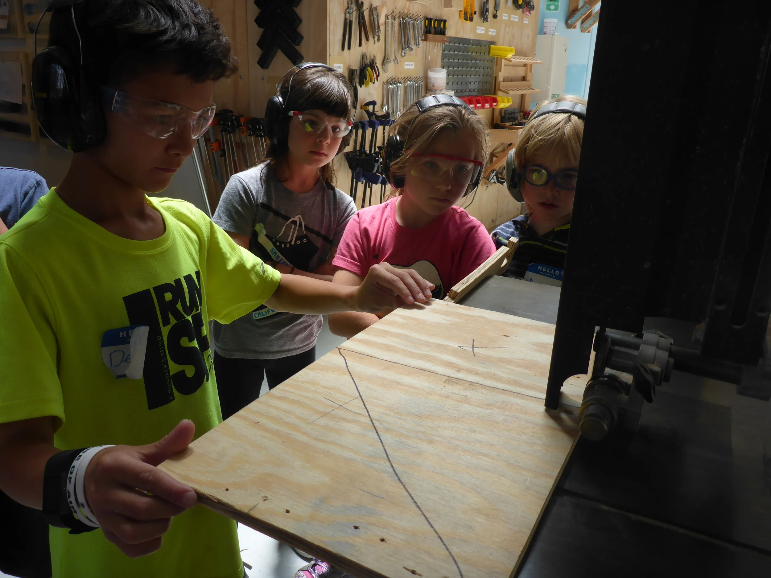 Devon cuts down some plywood triangles to help brace the corners of the vehicle. 