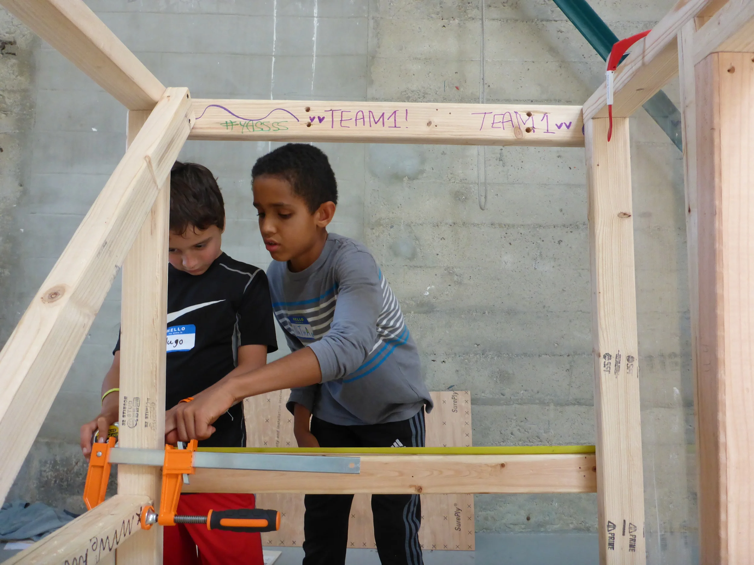 Hugo and Nathan work as a team to double check measurements on the vehicle's skeleton.
