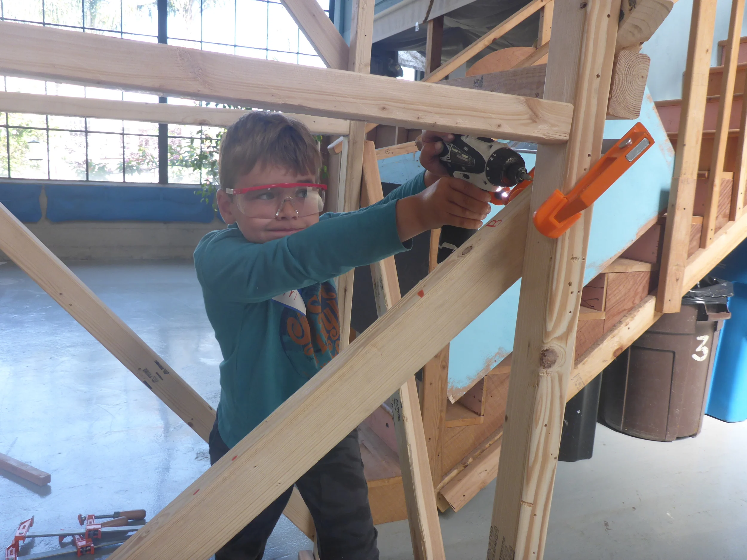 The only disadvantage to building really tall things is that it's sometimes very difficult to drive in screws that are above shoulder level. Ari is intensely focused on completing the bridge supports, even though the work is really hard!