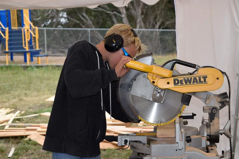 Ryker cuts wood on the chop saw for his team, the Kablooi