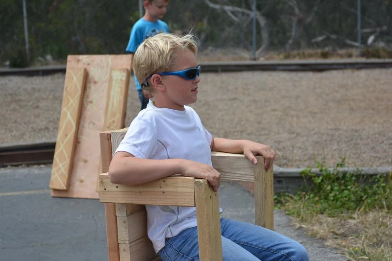 Portrait of a Tinkerer: Ryker sits in a chair of his own making