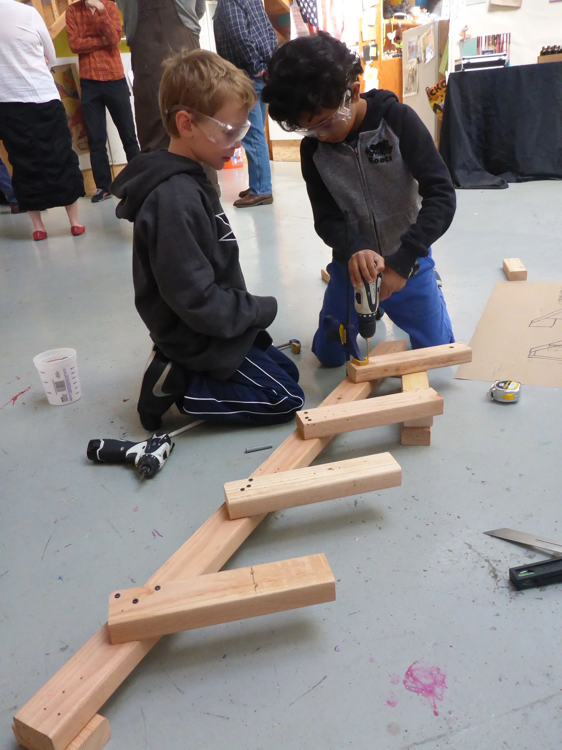 Gautam and Zach clamp and attach pieces of the stairs they are making.