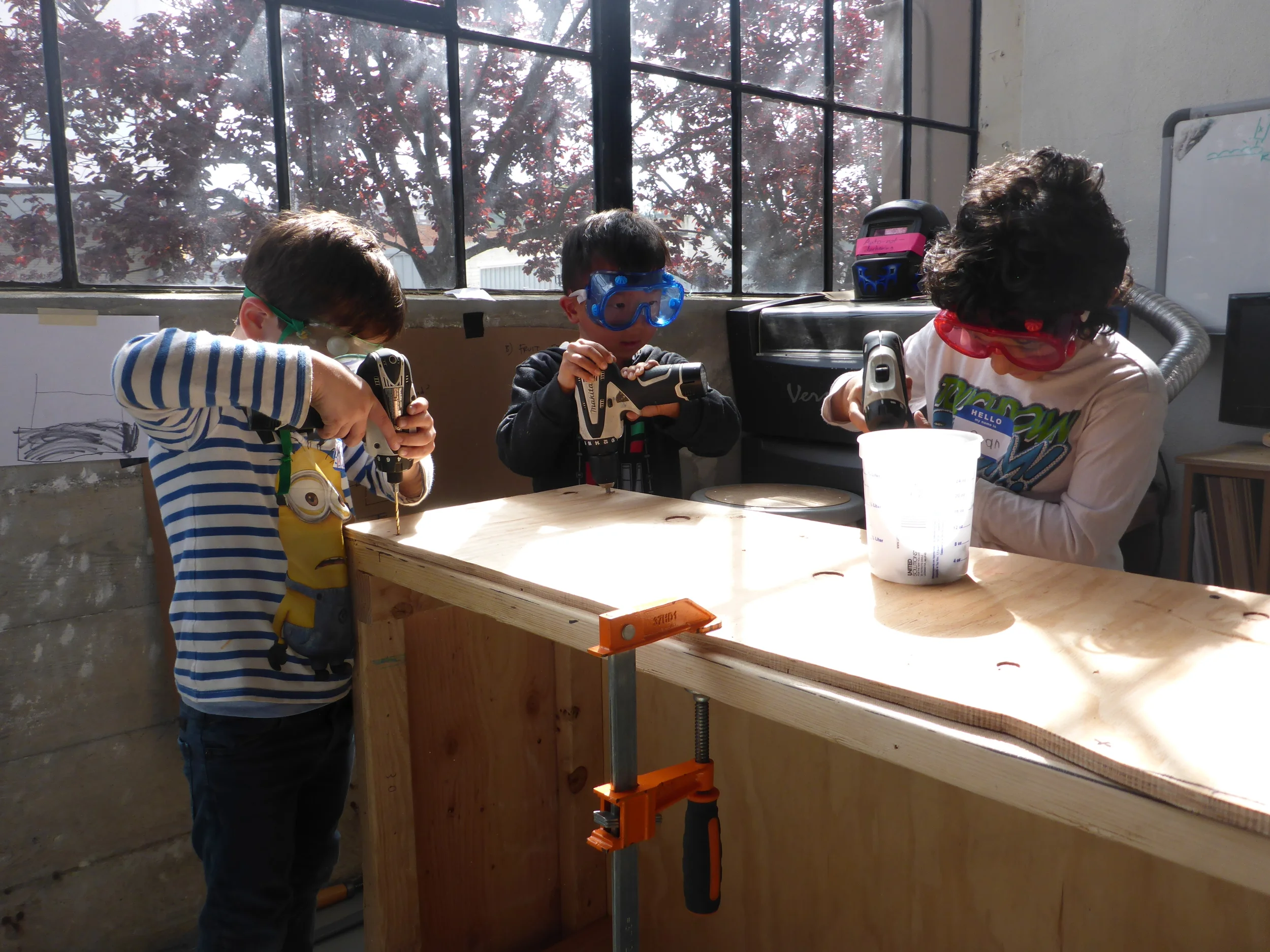 Anton, Ryan and Ryan attach plywood sides to the box they finished framing!