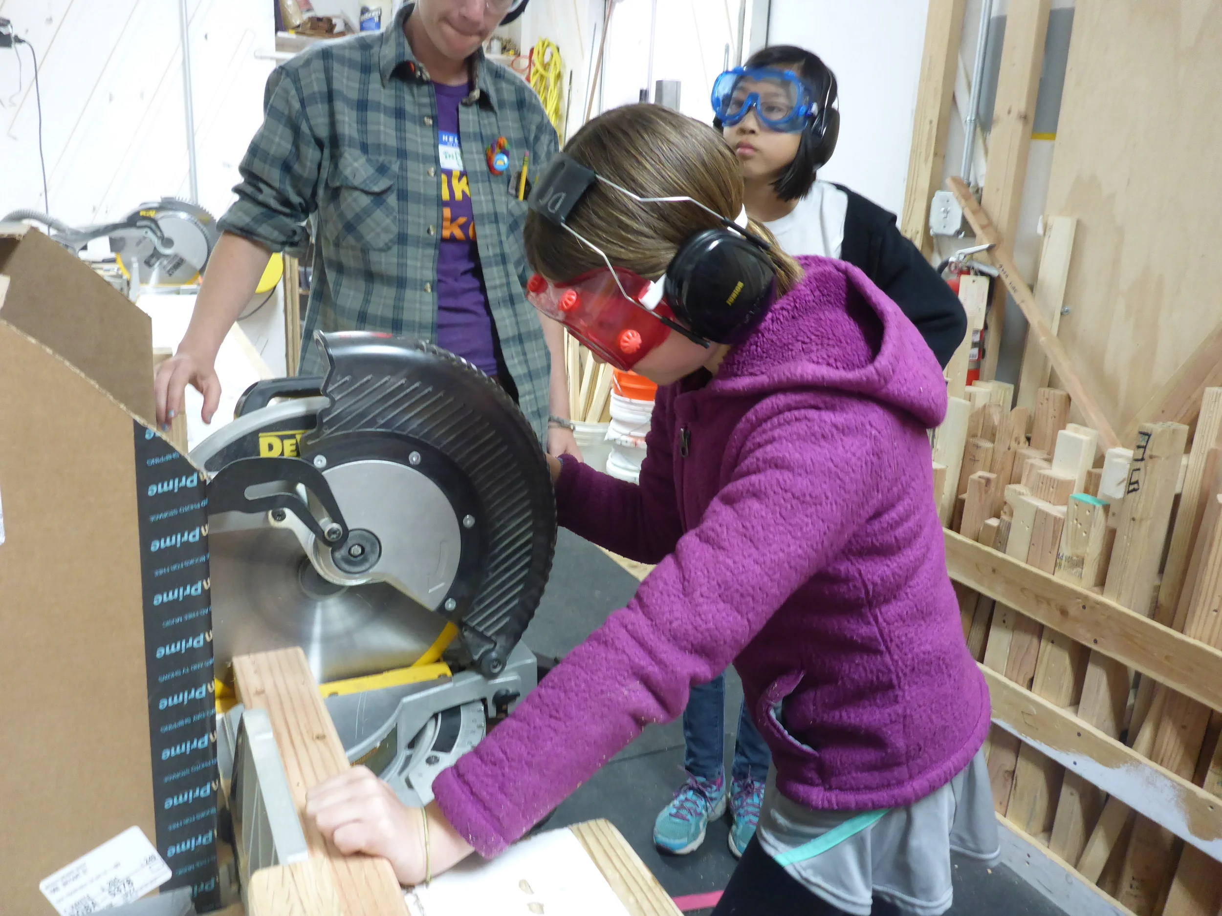 Lily mindfully practices using the chopsaw.