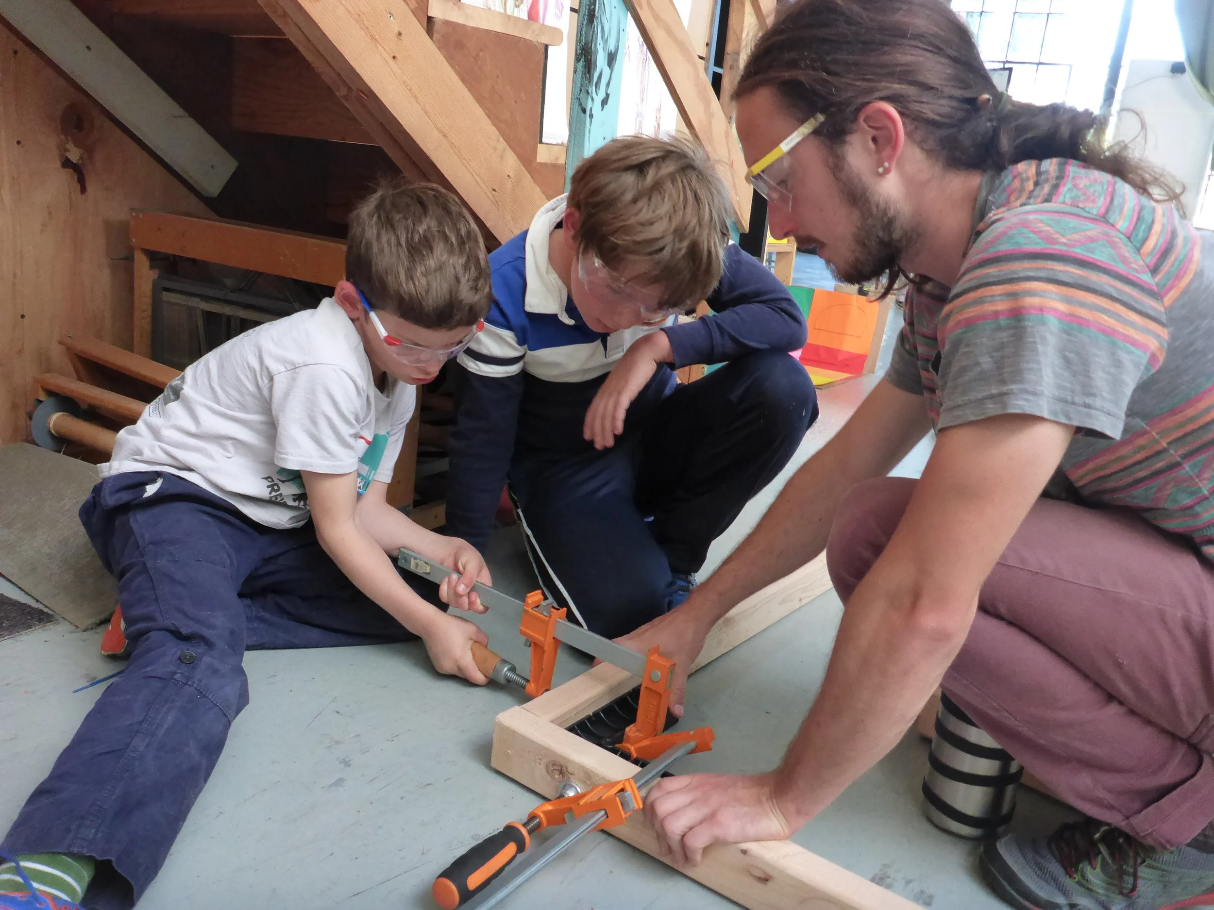 Casper, Alex and Evan figure out how to use the clamps and a square to make a nice square corner.