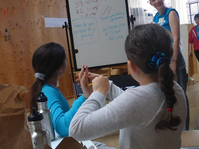 Madeleine uses Olivia's hand and arm to show us how a lever could trigger something.