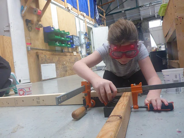 Jordan clamps a corner together, so she can drill.