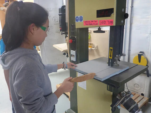 Maddy cuts foam on the bandsaw so we don't get "butt splinters" as we slide into the tank.