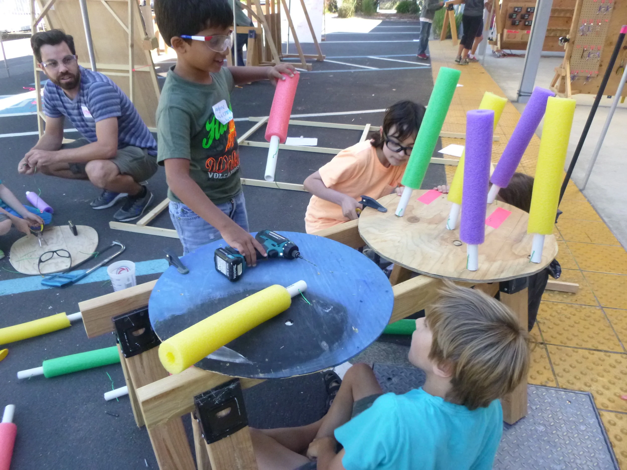 These pool-noodle/PVC/plywood contraptions are actually scrubber brushes. 