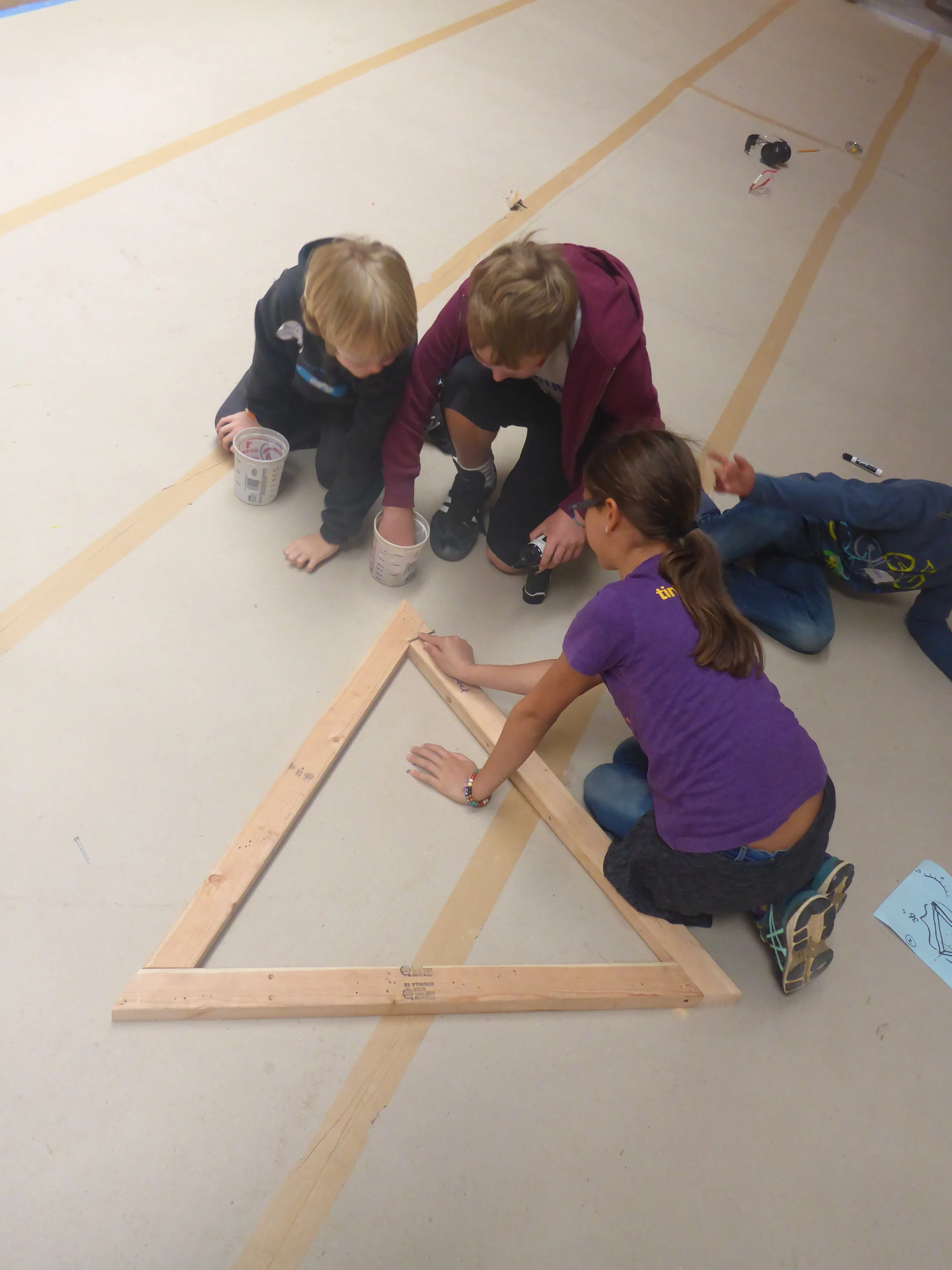 After fixing one of the boards (one was cut like a parallelogram instead of like a trapezoid, did you catch that?), Jasper, Wolf and Eve successfully built triangle number one!&nbsp;