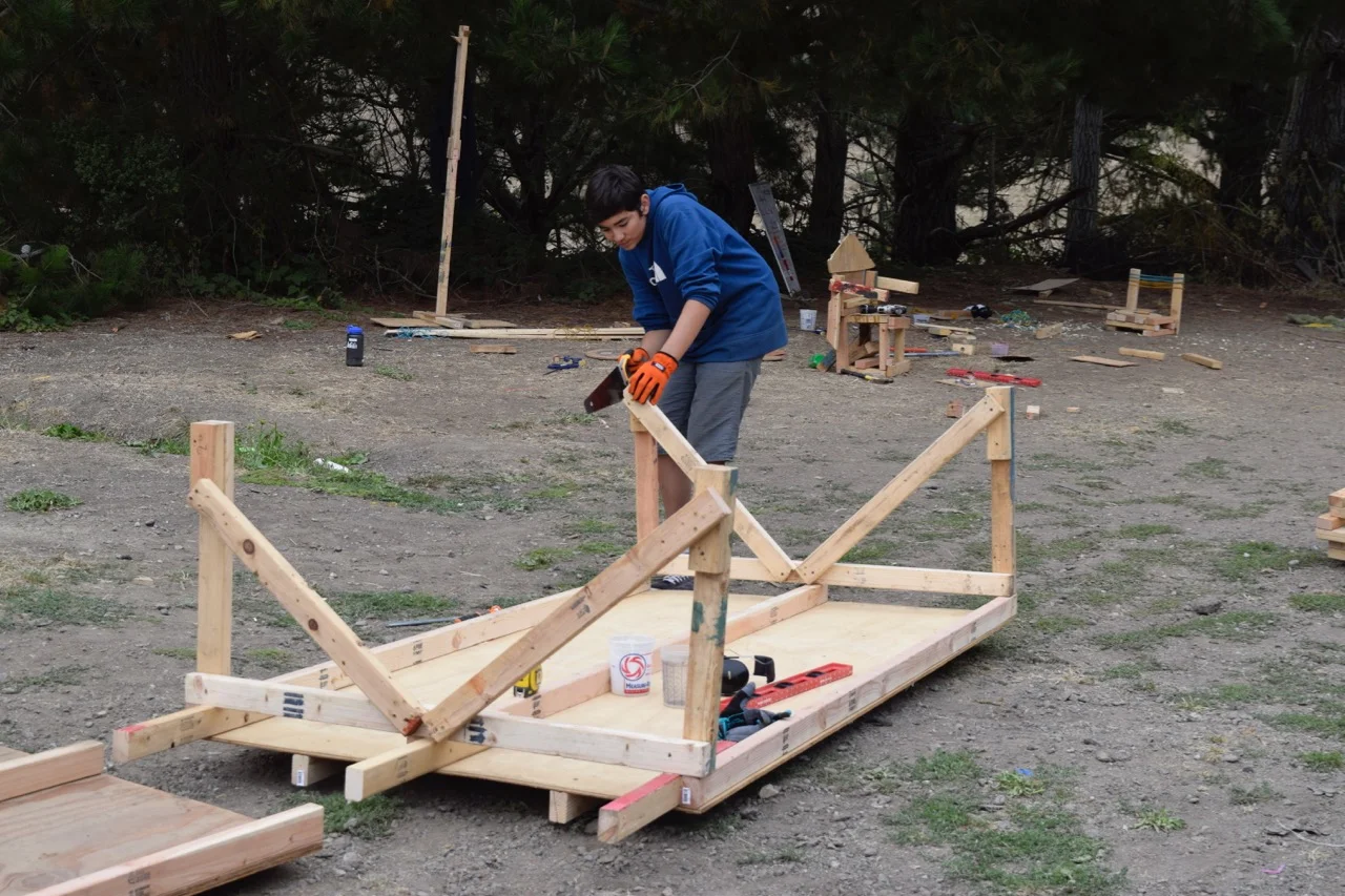 Evan handsaws the supports under the track so that they're flush.&nbsp;