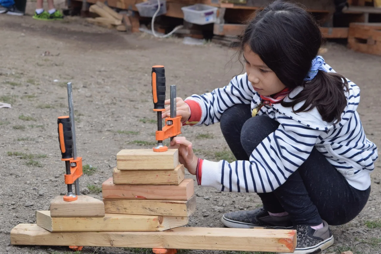 Kiana uses some clamps to stack 7 pieces of wood.