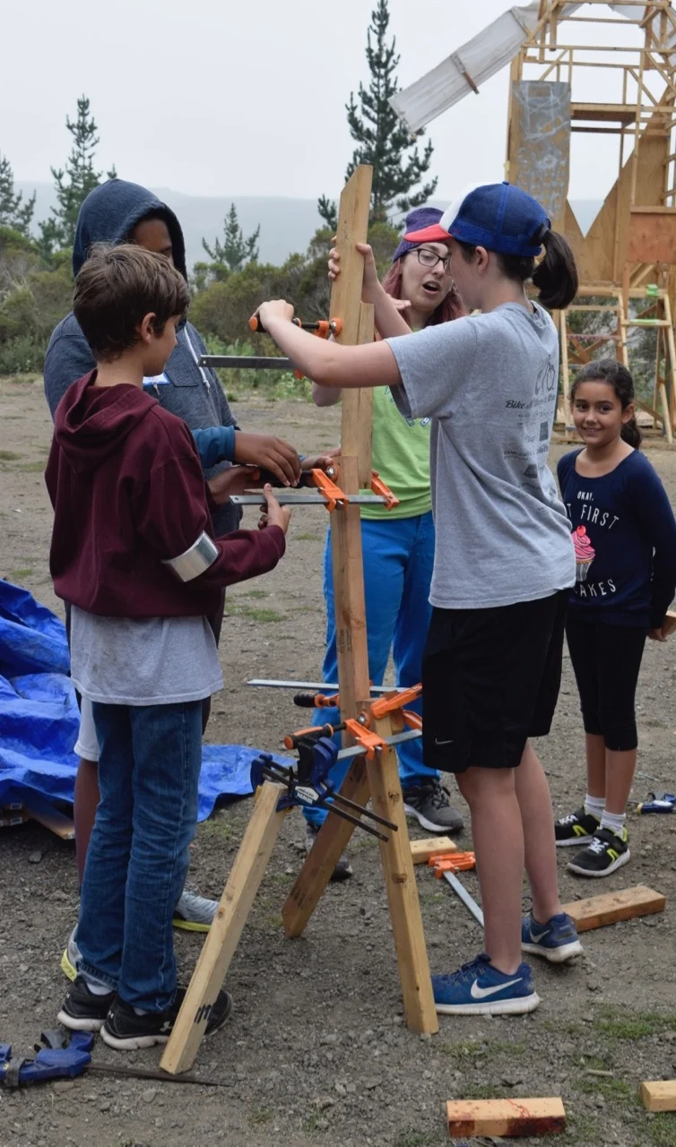 A group creates a tower held together only by clamps.