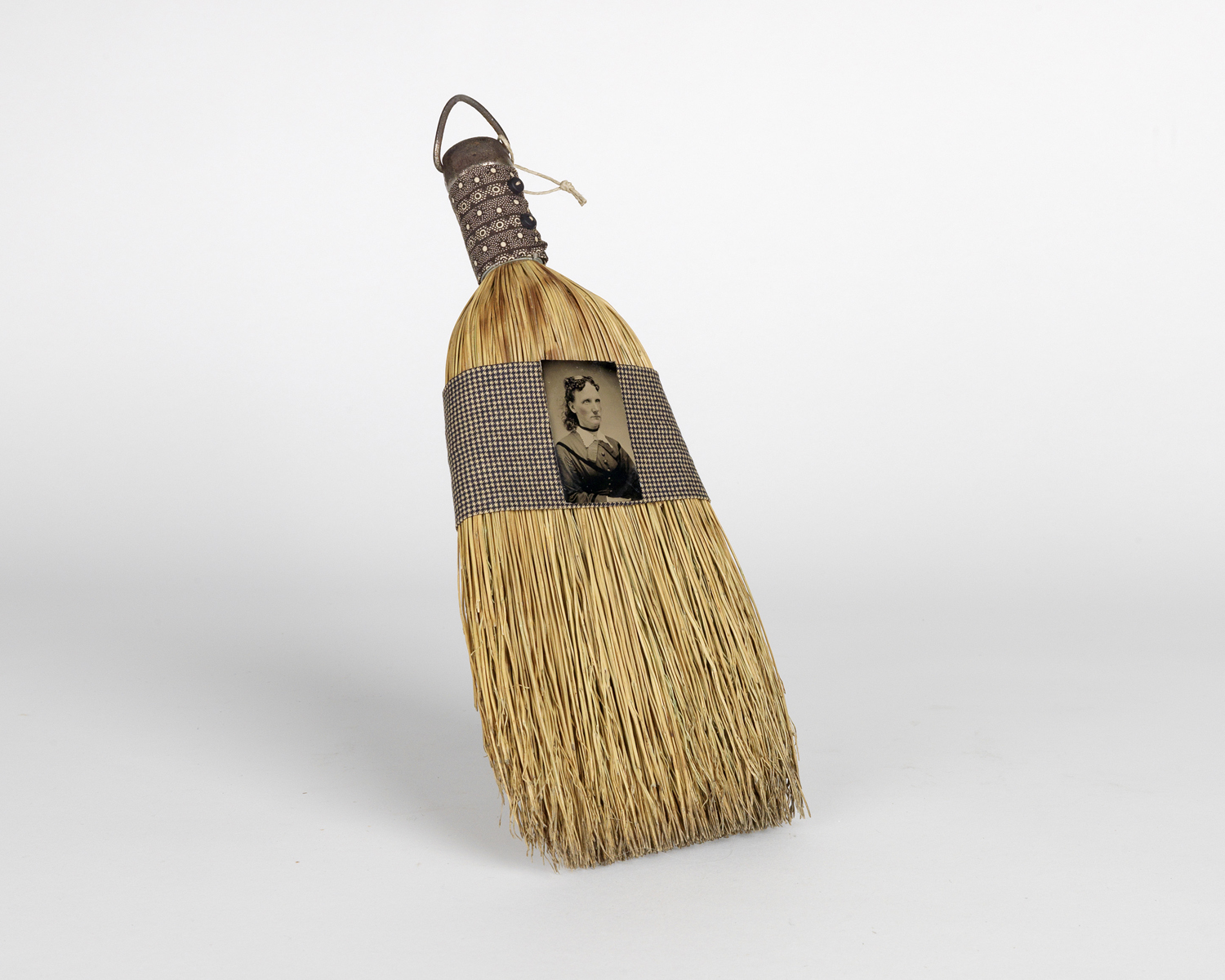    Reworked period broom adorned with a vintage tintype and fabric by artist Elaine Hunstman. 1880s-1990s   