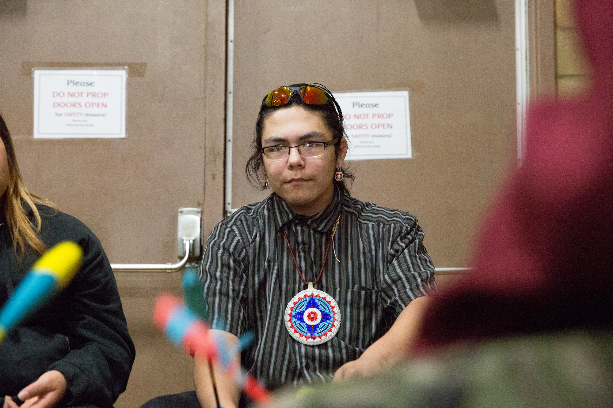 Teens gathered around a drum at A Youth Gathering of Native Americans.