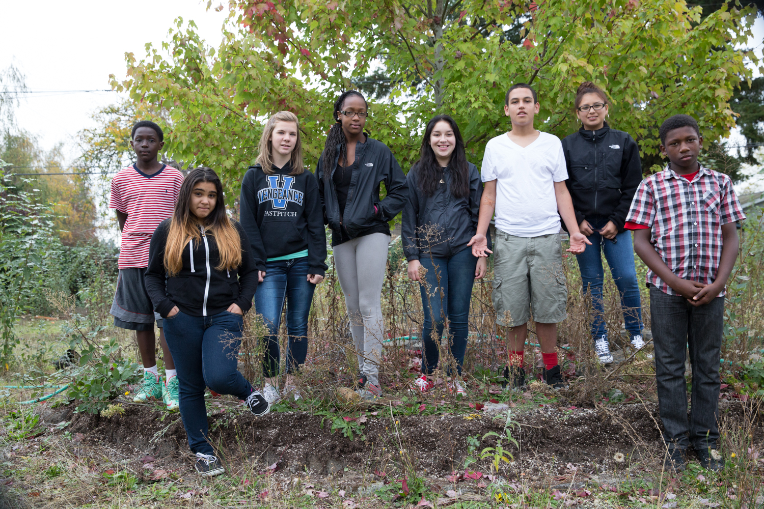 Several kids of various races and ethnicities lined up on a hillside.
