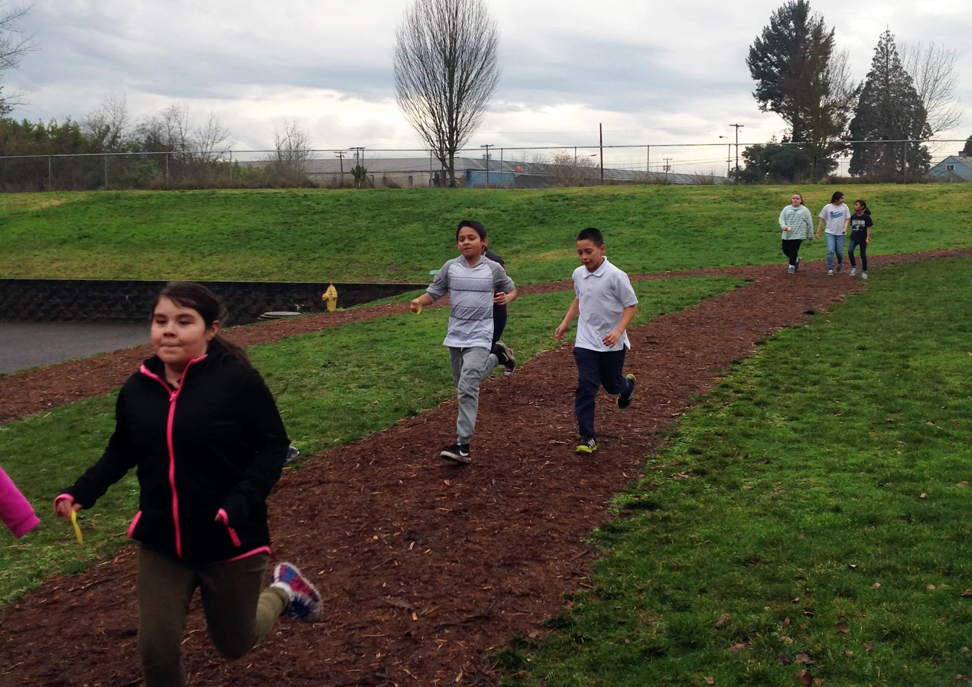 Kids running around a dirt track.