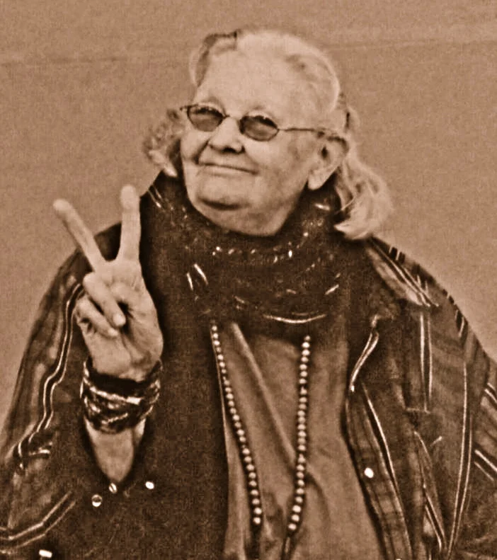 Grace Eagle Reed holds her fingers up in a “peace sign.”
