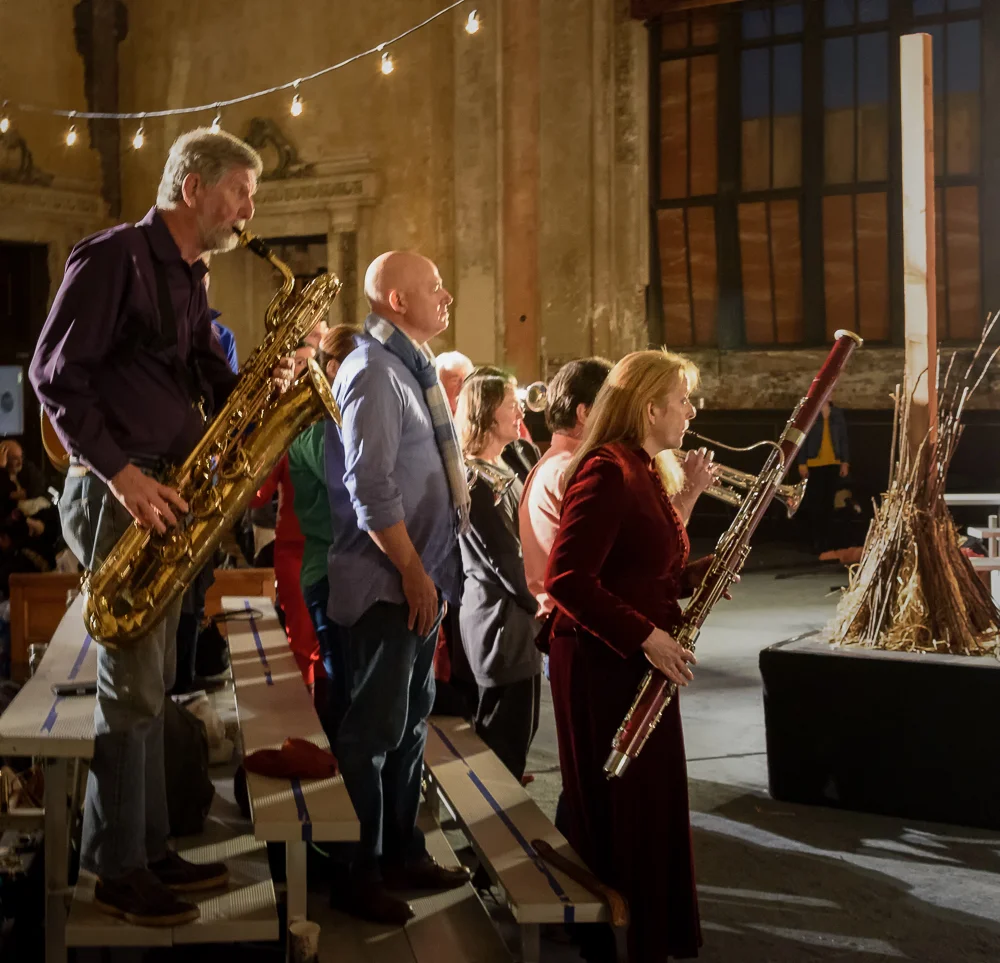 Amateur musicians in the audience provide musical punctuation for the Queen's pronouncements.