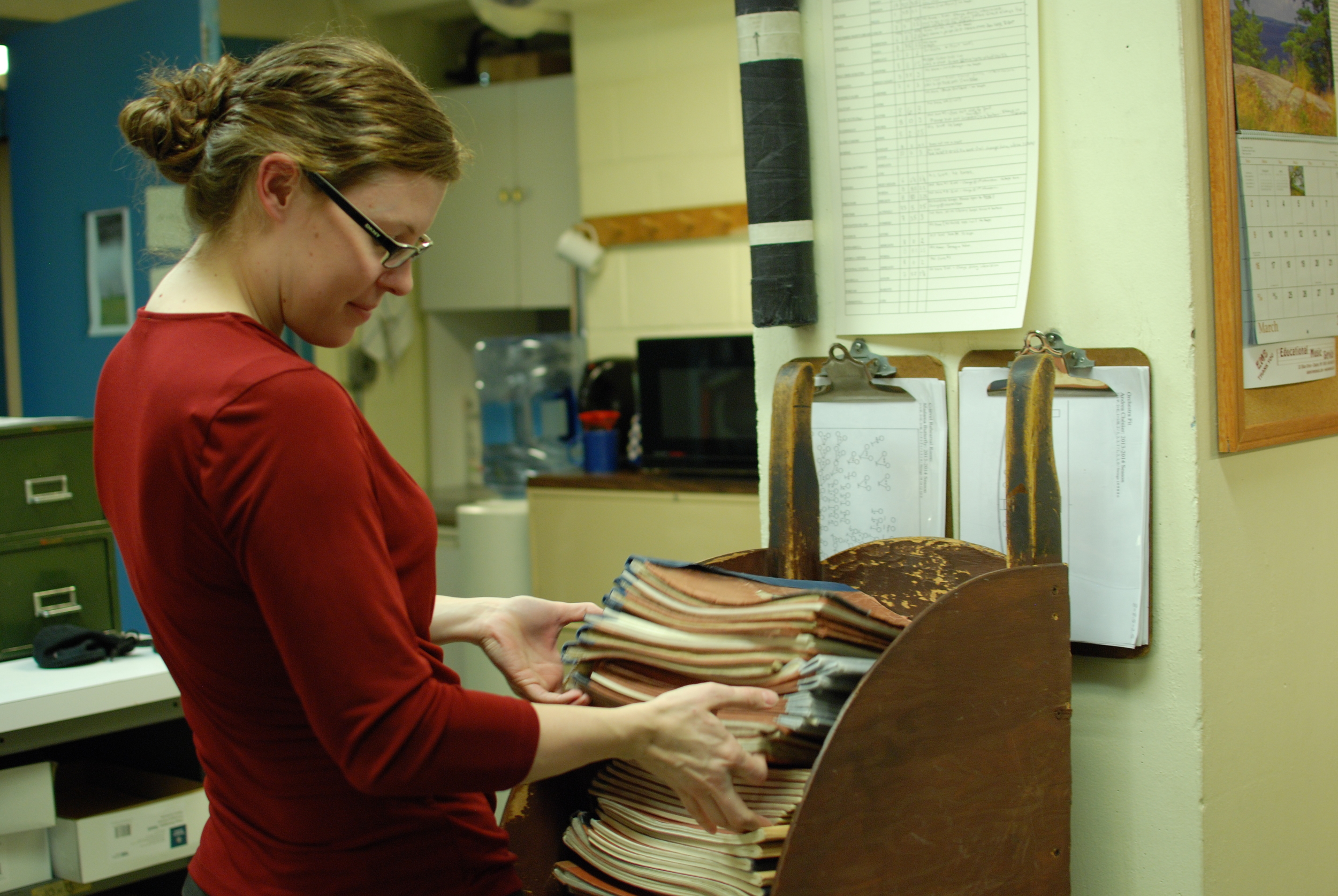 Melissa Robason counts parts collected after an orchestra rehearsal.