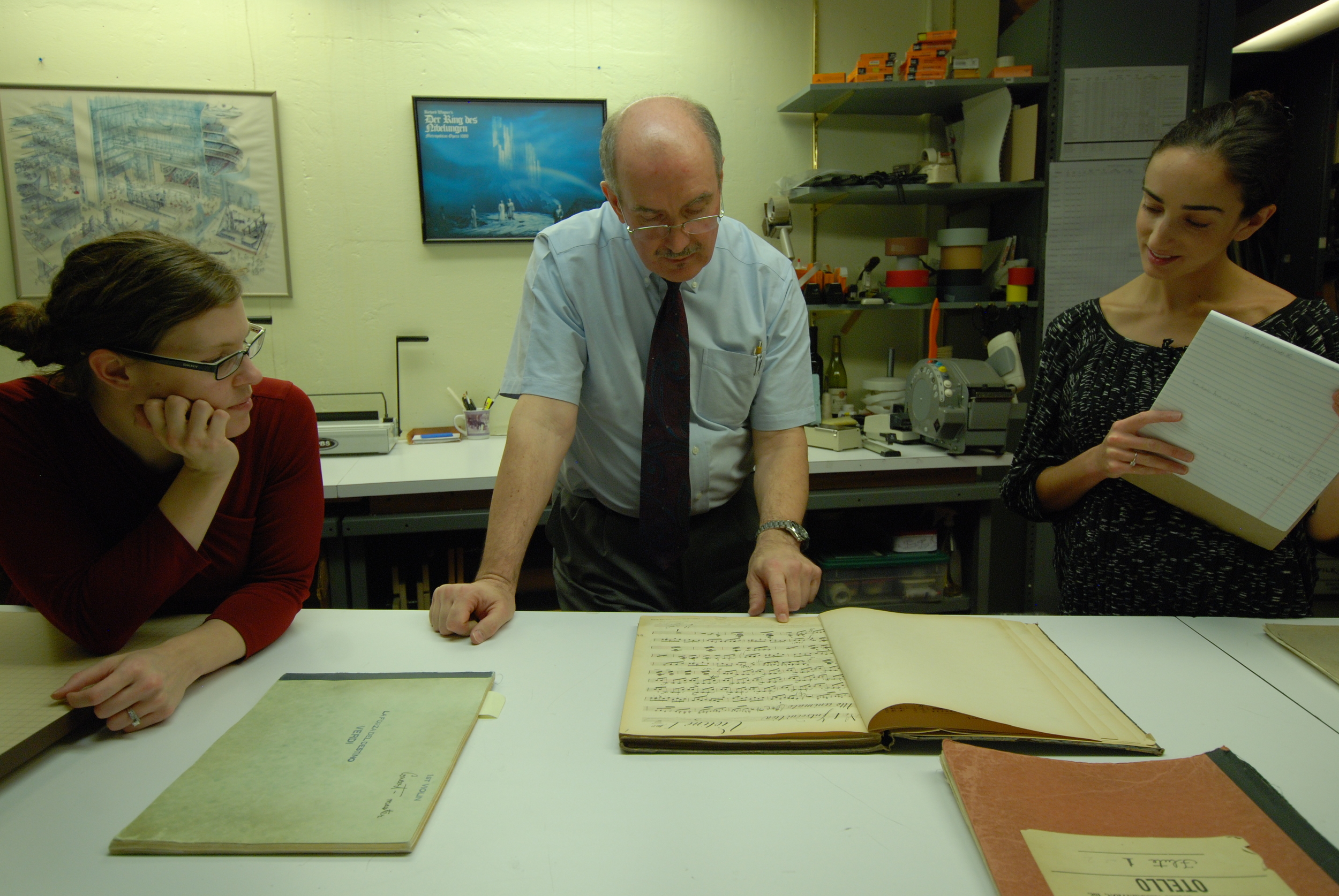 Melissa Robason, Robert Sutherland, and Sarah Vonsattel study an historic violin part of Wagner's Rienzi .