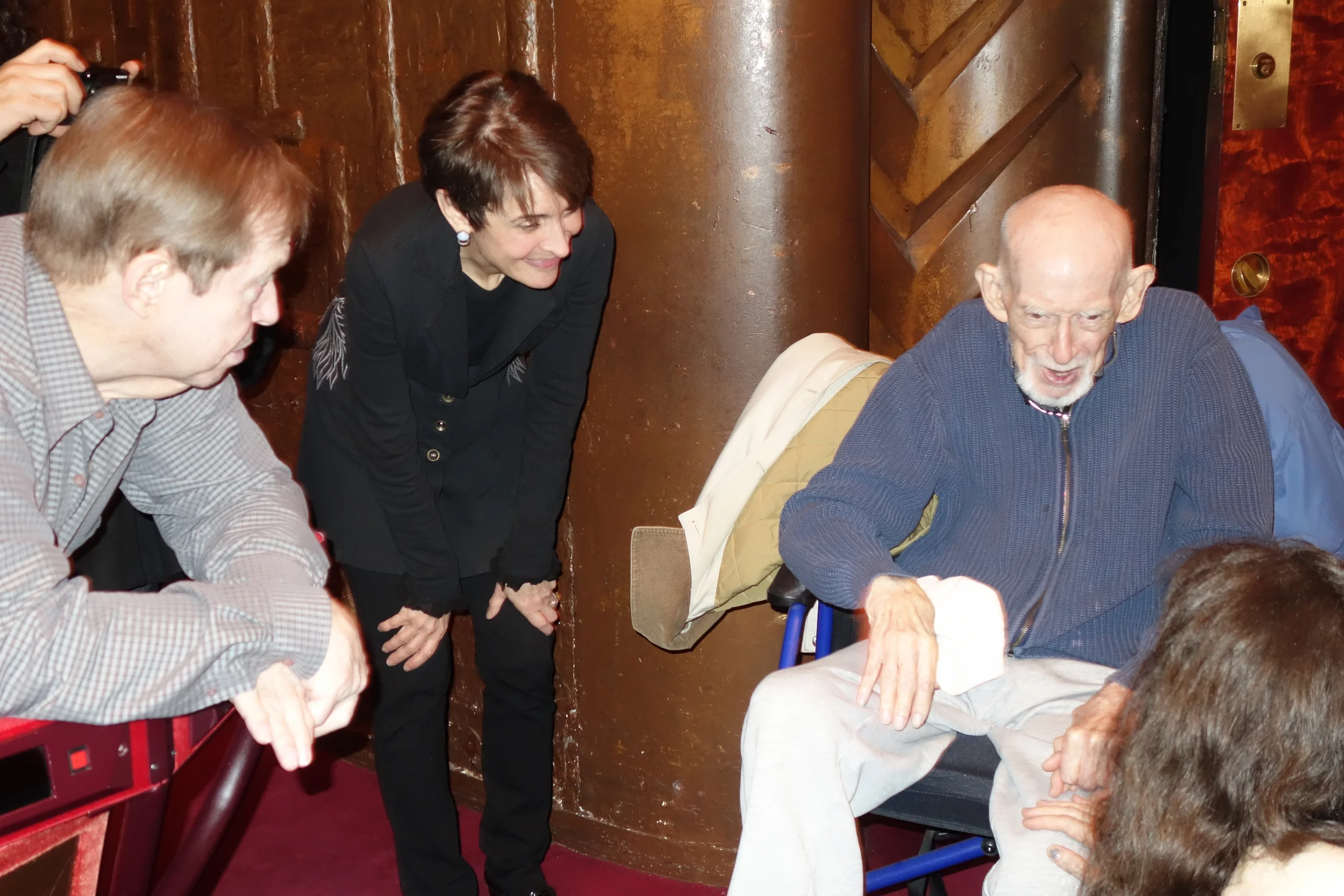 Elster chats with his granddaughter while oboist Elaine Douvas and trombonist Steve Norrell look on.