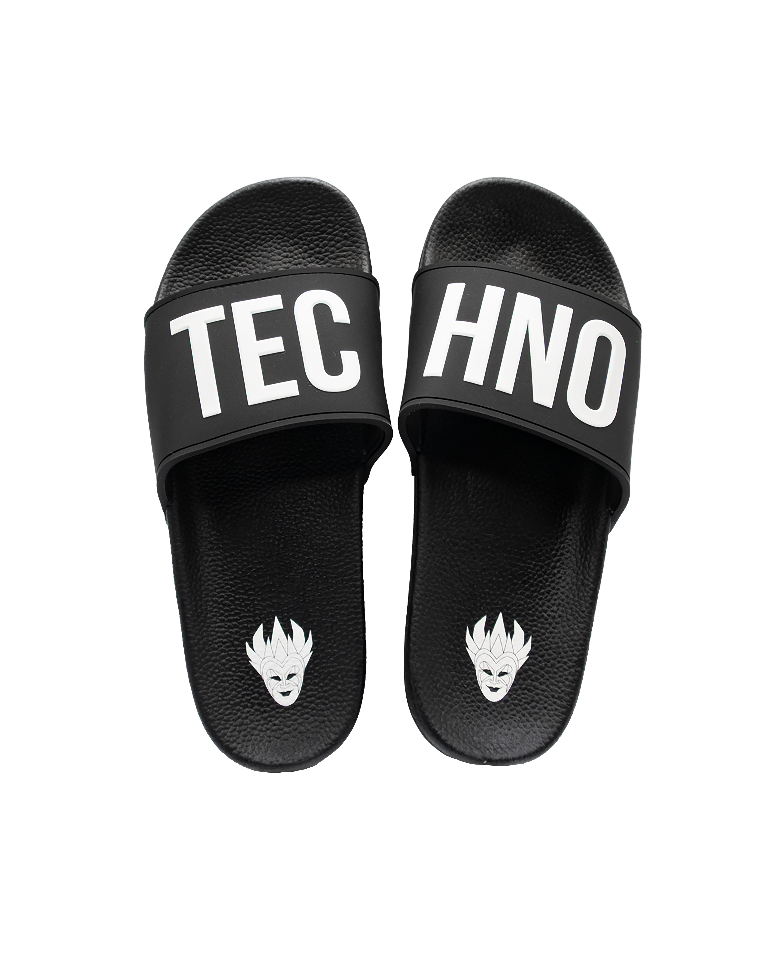 Black slip-on sandals with the word 'TECHNO' printed in bold white letters on the straps, and a white stylized face graphic on the footbed.