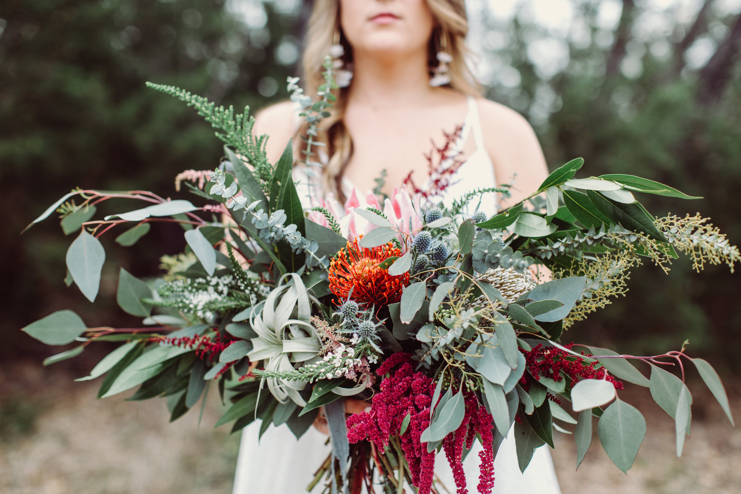  Bohemian style,  wildflower inspired bridal and bridesmaid bouquets with eucalyptus, protea, thistle, astilbe Petal Pushers floral event design studio located in Dripping Springs, Texas. 