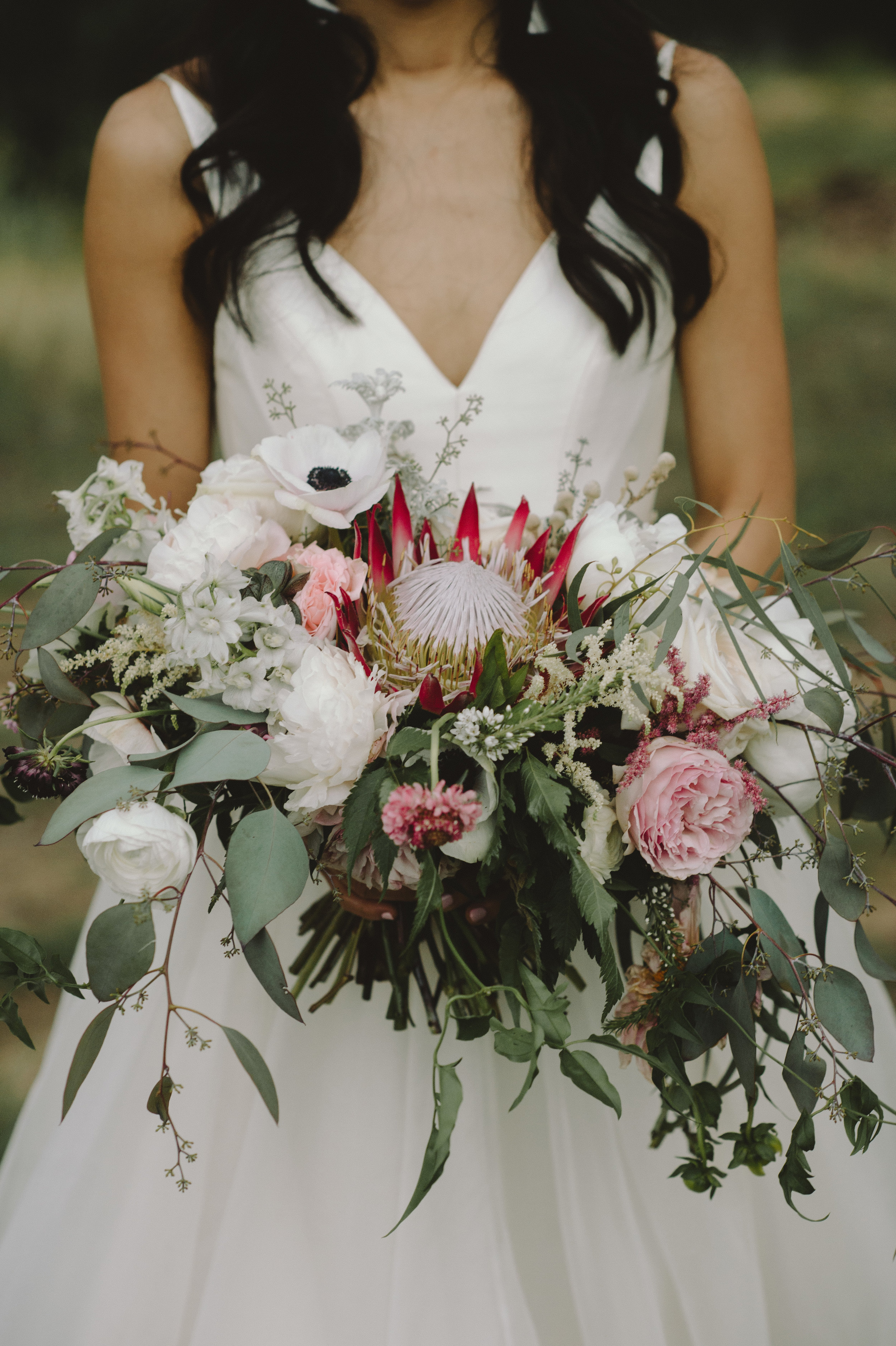  Bohemian style, wildflower inspired bridal and bridesmaid bouquets with Anemone, eucalyptus, protea, peonies at Vista West Ranch. Petal Pushers floral event design studio located in Dripping Springs, Texas. 