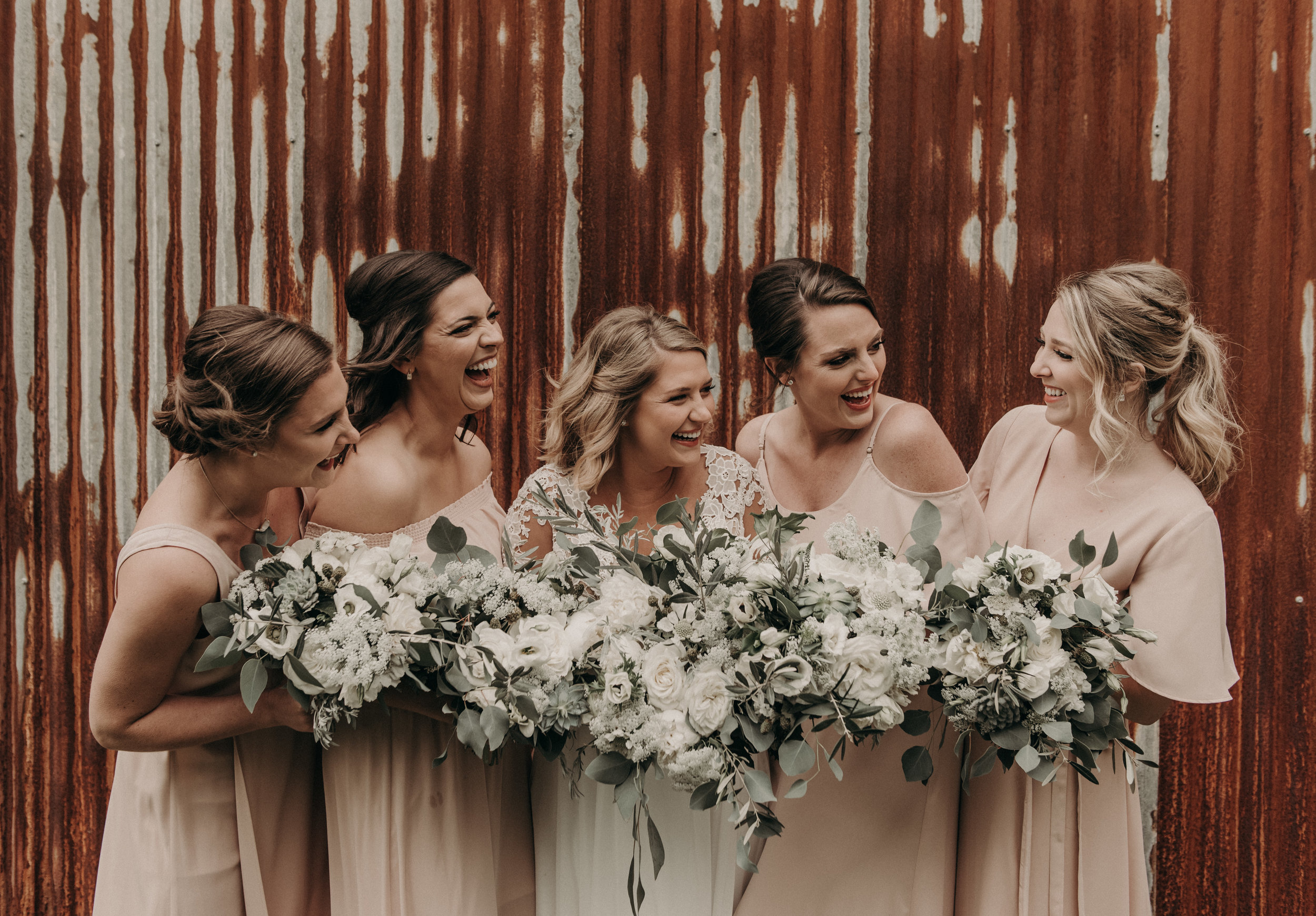  Bohemian style, wildflower inspired bridal and bridesmaid bouquets with white garden roses, eucalyptus, anemone, ranunculus at The Creek Haus. Petal Pushers floral event design studio located in Dripping Springs, Texas. 