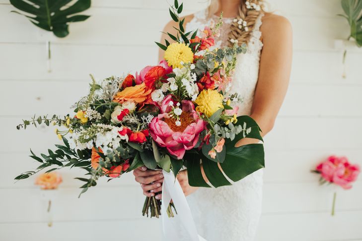  Bohemian style, tropical inspired bridal bouquet with pink, yellow, and coral charm peonies. Petal Pushers floral event design studio located in Dripping Springs, Texas. 