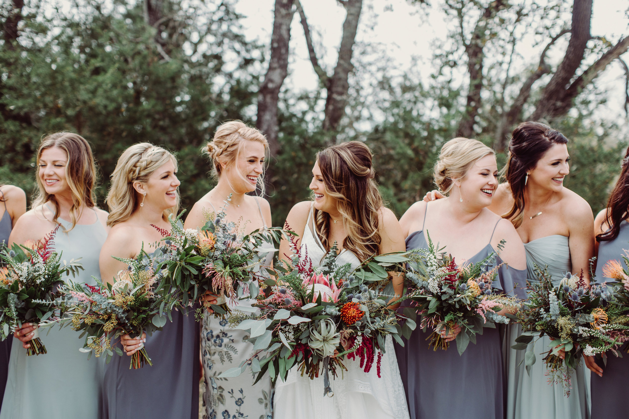  Bohemian style, wildflower inspired bridal and bridesmaid bouquets with eucalyptus, protea, thistle, astilbe Petal Pushers floral event design studio located in Dripping Springs, Texas. 