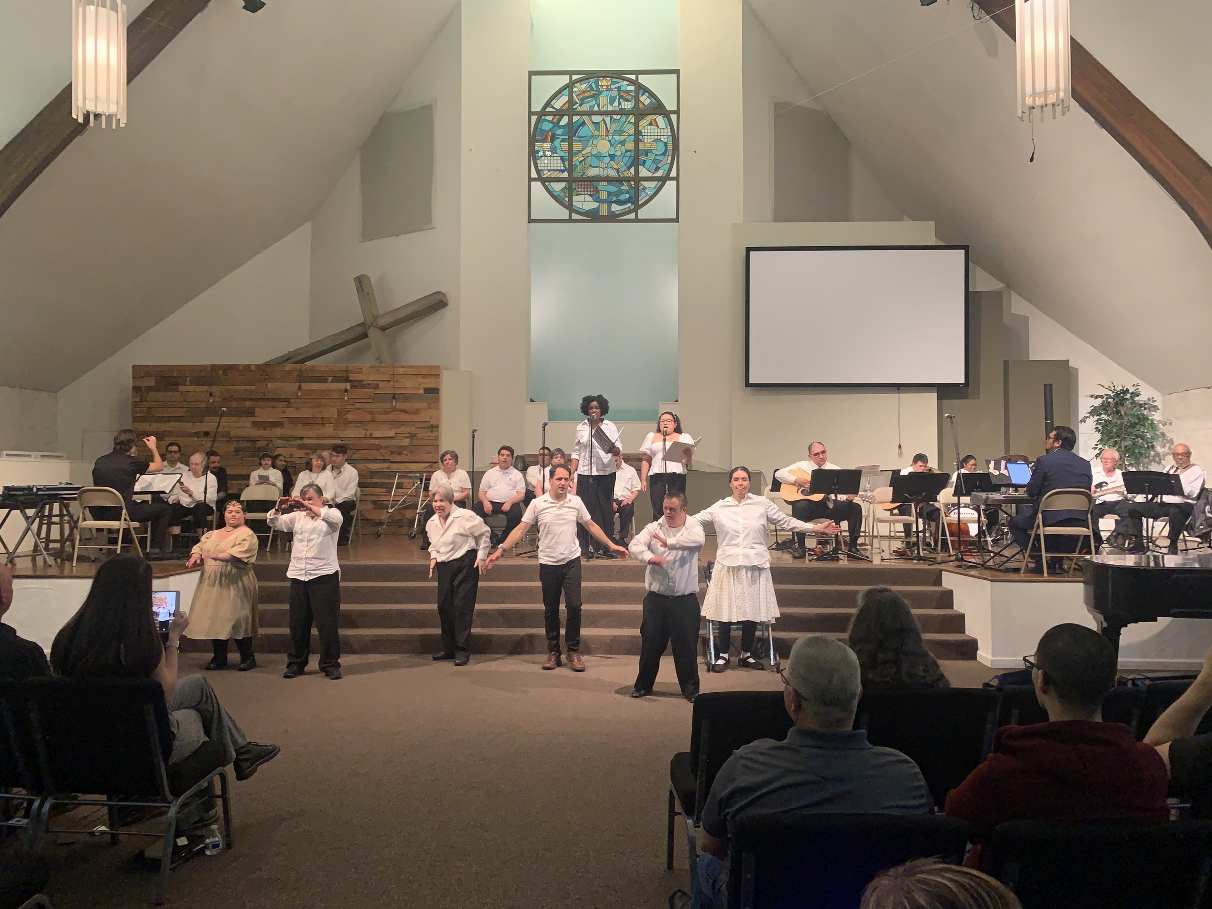  Creative Identity Anaheim participants singing, dancing, and playing instruments for their 2023 Summer Concert and Boutique called “Coming Together as a Community” to an audience of attendees. 