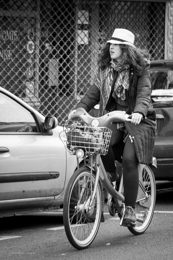 A woman in Paris travels on a rented bicycle.