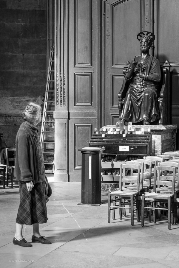 A woman gazing at Saint Peter at Église Saint-Sulpice in Paris.