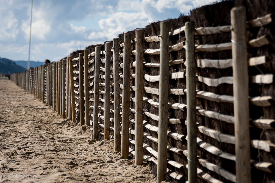 The fence along the beach in Deauville, France has many intriguing details that conjure up my memories of the day. I wish I had changed my angle so the pole wasn't visible, and to have waited until the woman wasn't peeking over the fence! My learning continues...
