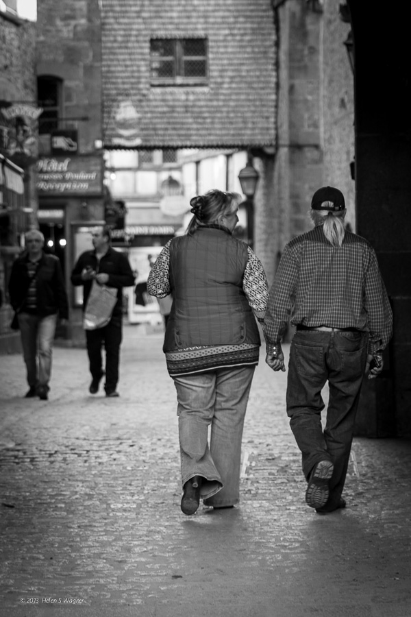 A couple ambles along the cobblestones at Mont St-Michel.