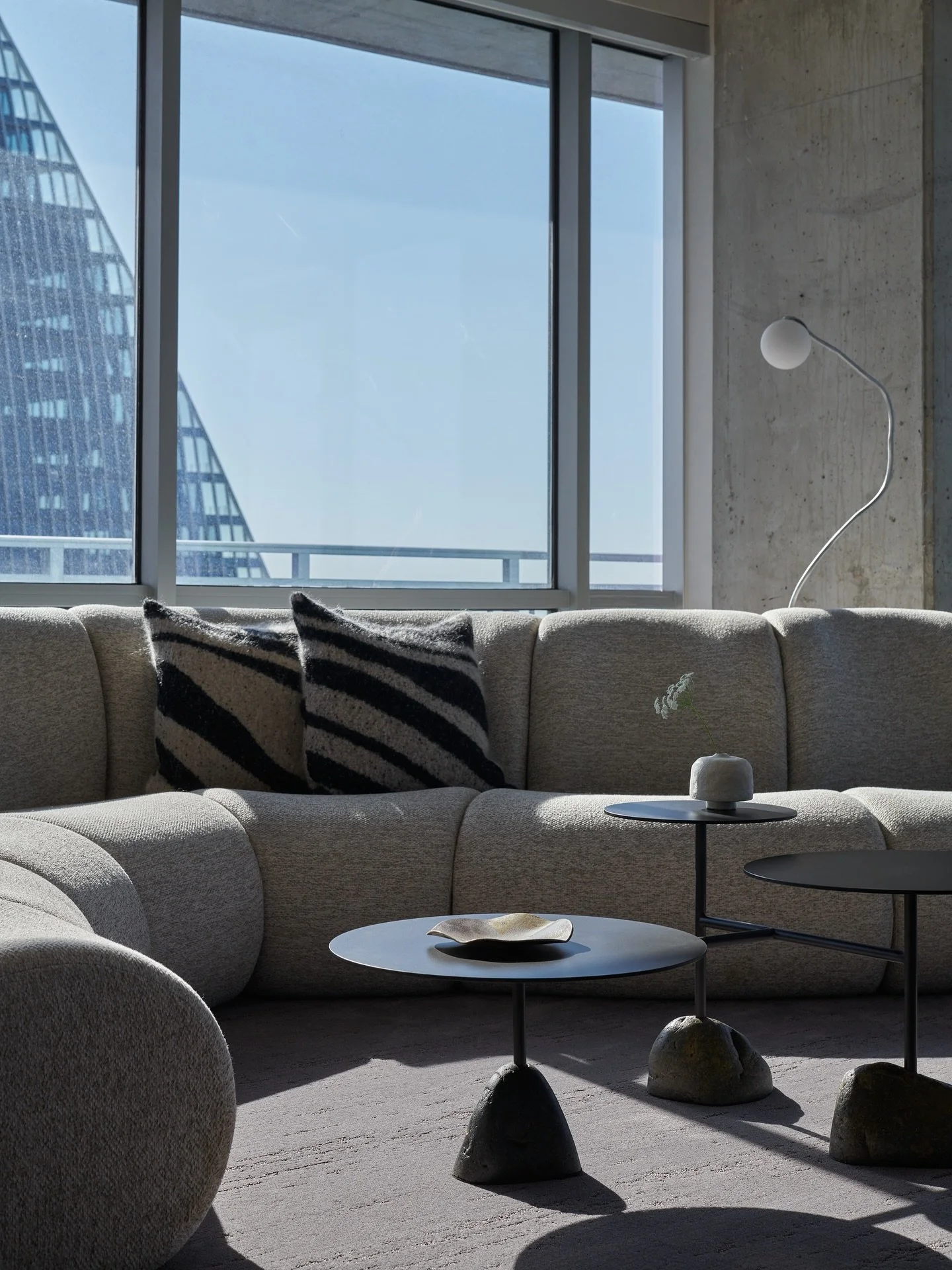 Chic in the sky and rooted in texture, this soft space is a beautiful blend of organic and modern. A custom serpentine sectional wraps around a favorite @stephenkenn stone grounded steel coffee table.