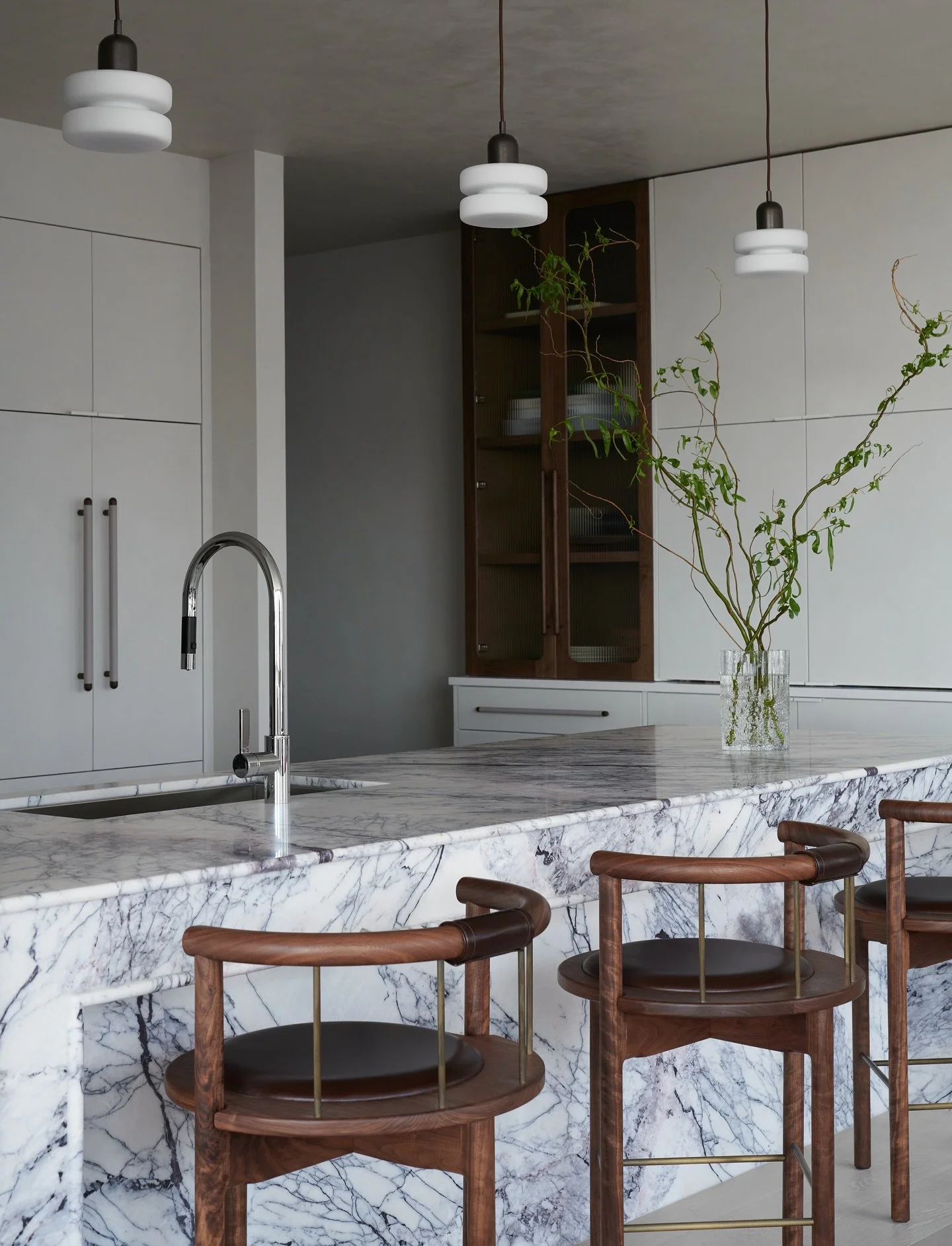 A sea of lilac marble and bespoke craftsmanship elevates this kitchen. Layered plaster, leather wrapped pulls, and warm walnut tones for an elegant finish. Captured by @hannagrankvist